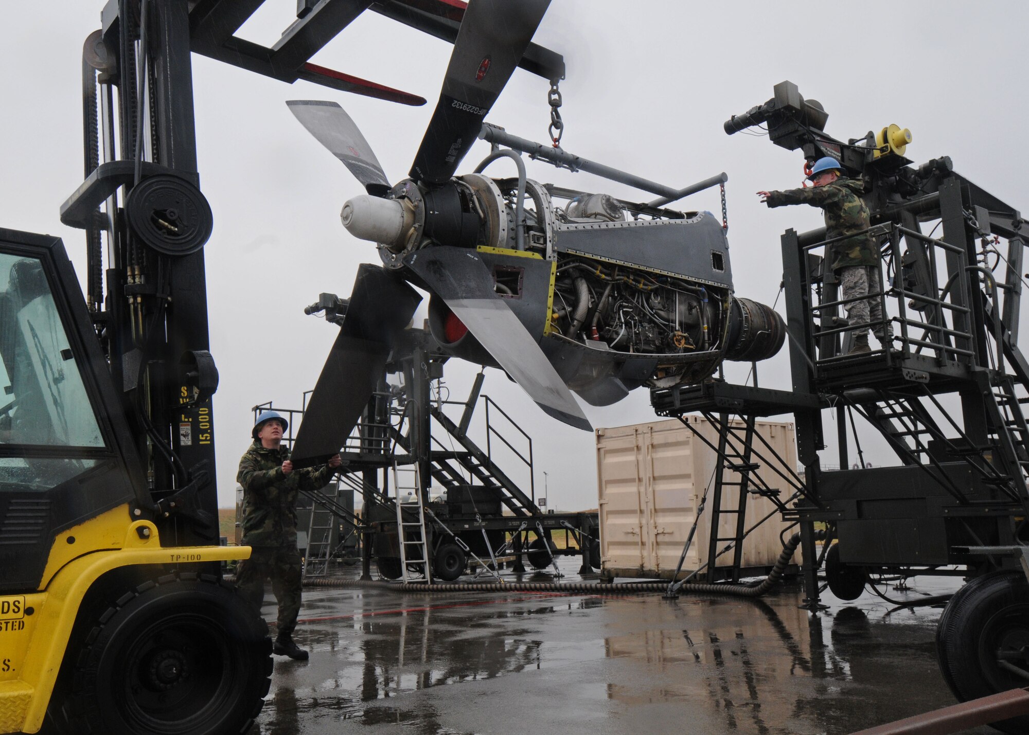 YOKOTA AIR BASE, Japan -- Senior Airman Mathew Vineyard, left, and Airman 1st Class James Kliever attach a T56 engine to a maintenance stand in preparation for testing Dec. 17. The Airmen work for the 374th Maintenance Squadron engine test cell. (U.S. Air Force photo by Senior Airman Veronica Pierce)
