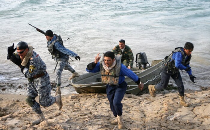 Police officers training to be officers with the al-Anbar Iraqi River Police run ashore after practicing an insert technique Dec. 21 on Lake Thar Thar, Iraq. Sailors with Detachment 3, Riverine Squadron 1, Regimental Combat Team 5 conducted a week-long course to instruct select Iraqi policemen on how to conduct independent boat operations on the lake and surrounding waterways.  ::r::::n::