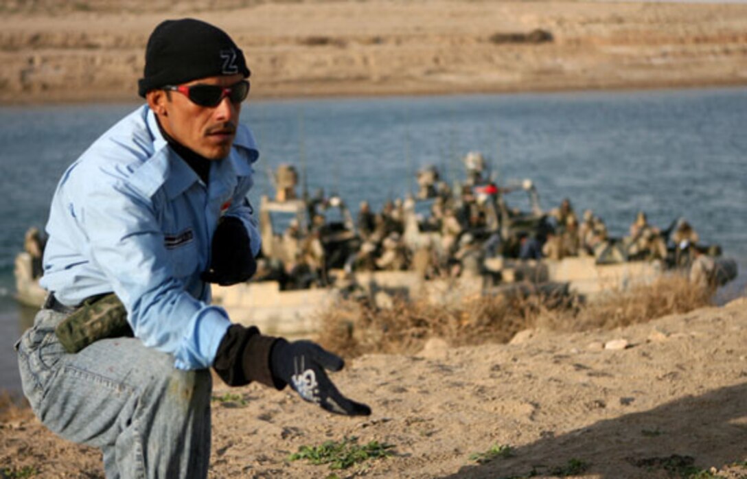 An Iraqi police officer provides security during a training exercise Dec 21 on Lake Thar Thar, Iraq. Sailors with Detachment 3, Riverine Squadron 1, Regimental Combat Team 5 conducted a week-long course on the lake to qualify approximately 35 Iraqi police officers to be officers with the al-Anbar Iraqi River Police. The role of the river police is to patrol the waterways independently from Coalition forces ensuring the safety of the local populace. ::r::::n::