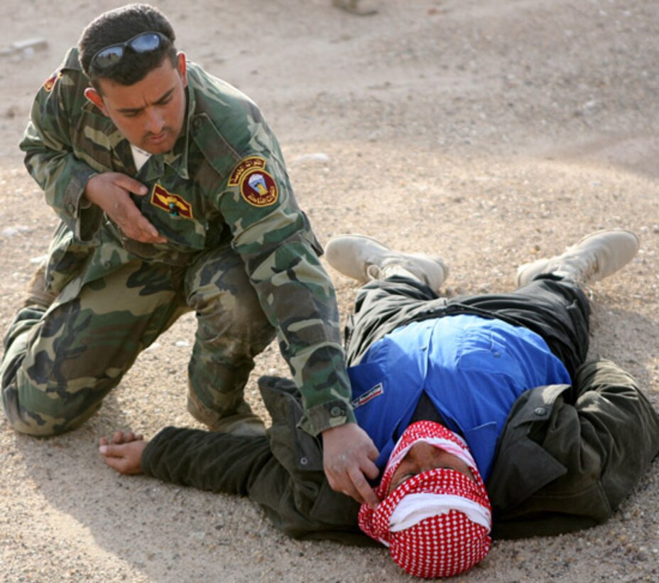 â??Muhammed,â? an Iraqi police officer, checks on a simulated insurgent casualty during a training exercise Dec. 21 on Lake Thar Thar, Iraq. The class was taught by Detachment 3, Riverine Squadron 1, Regimental Combat Team 5. The "River Rats," as the squadron is called, held a week-long class to qualify select Iraqi police officers to be officers with the al-Anbar Iraqi River Police.::r::::n::