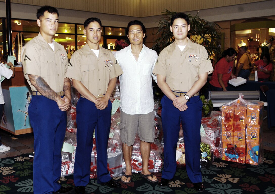 Lance Cpls. Byron Cheek-Enriquez, Isaac Yuen, and Kenji Conley pose with 'Lost' actor Daniel Dae Kim after he donated 500 new toys to the Marine Corps Reserve's 2008 Toys for Tots campaign at Kahala Mall here Dec. 22. After hearing that the campaign was short of its goal this year, Kim wanted to do his part to help the less-fortunate, he said.