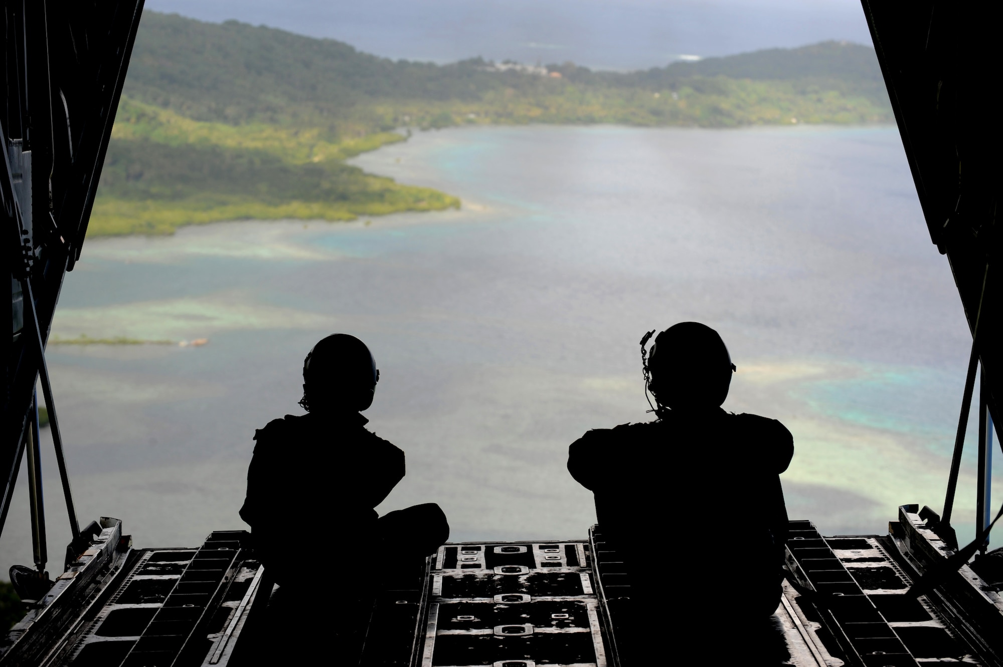 (left) Senior Airman Robert Gore, and Airman 1st Class Dustin Deveaux observe the drop zone Dec.19 over the remote Island of Yap, from a C-130 Hercules during Operation Christmas Drop. In all, more than 180 boxes were built for the humanitarian mission, making 2008 one of the largest drops in Operation Christmas Drop's 57 year history. Airmen today continue the tradition delivering supplies to remote islands of the Commonwealth of the Northern Marianas Islands, Yap, Palau, Chuuk and Pohnpei. Both crewmembers are from the 36th Airlift Squadron, Yokota AB, Japan. (U.S. Air Force photo/ Master Sgt. Kevin J. Gruenwald) released
