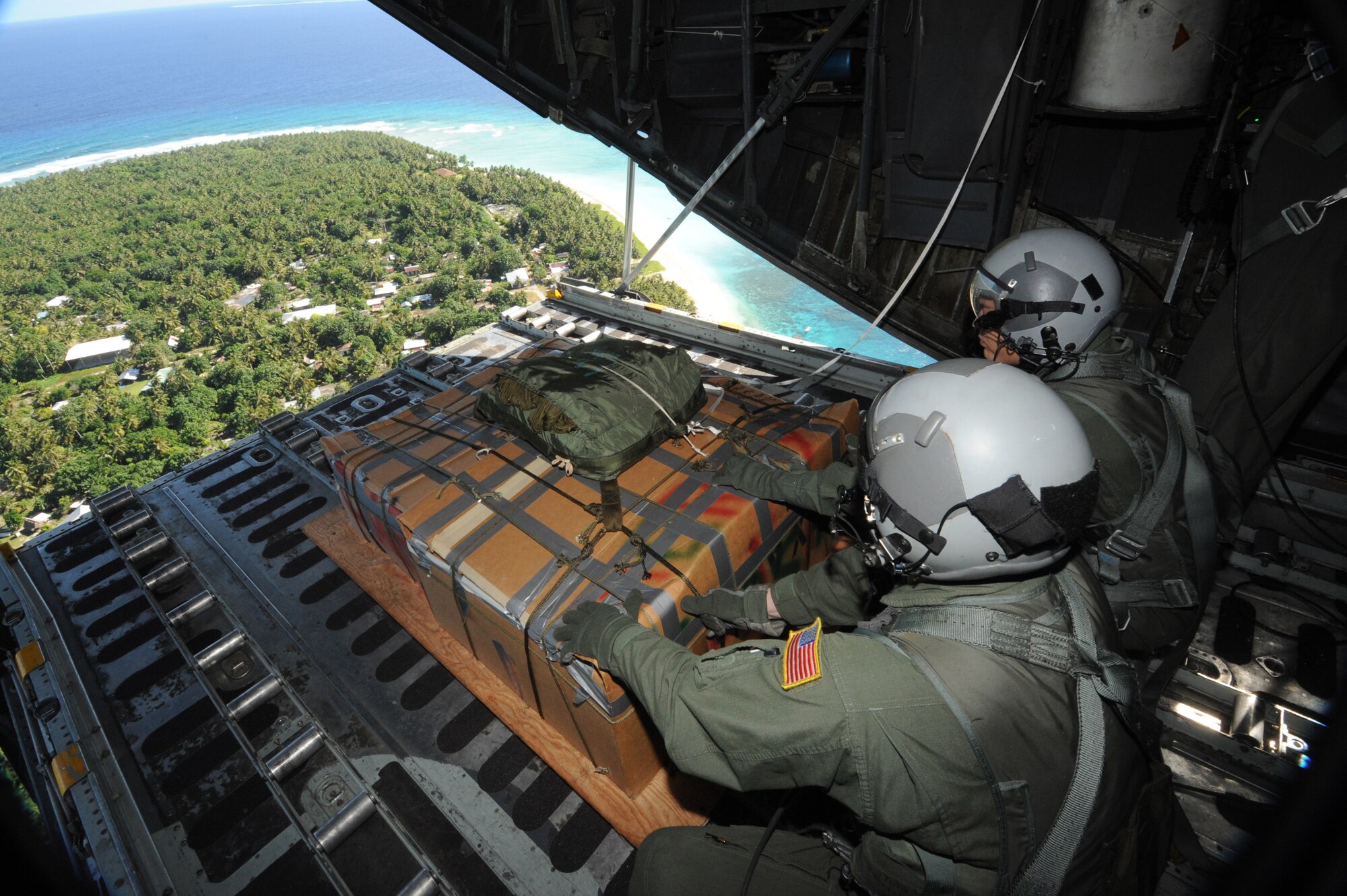 (left) Tech. Sgt. Heath Bahyi and crewmember wait for the right moment Dec. 19 to push a boxed pallet of donated supplies from a C-130 Hercules over the remote Island of Yap to be dropped during the 2008 Operation Christmas Drop. Operation Christmas Drop is the Air Force's longest-running humanitarian mission which began in 1952. Through military and local community support, the operation has collected tens of thousands of donated items and raised more than $30,000 in support. Airmen today continue the tradition delivering supplies to remote islands of the Commonwealth of the Northern Marianas Islands, Yap, Palau, Chuuk and Pohnpei. Sergeant Bahyi is a loadmaster from the 36th Airlift Squadron, Yokota AB, Japan.
(U.S. Air Force photo/ Master Sgt. Kevin J. Gruenwald) released