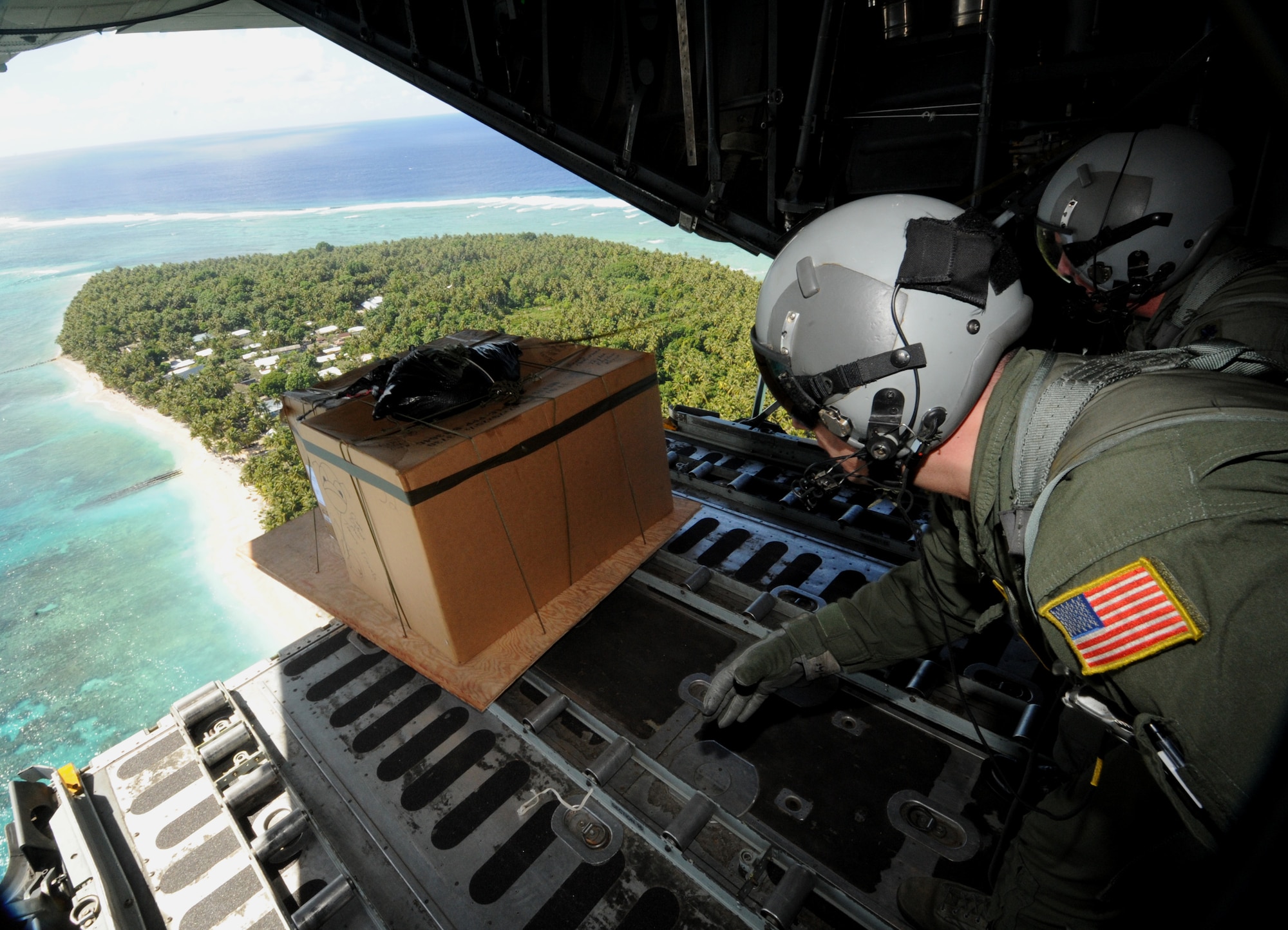 (left) Tech. Sgt. Heath Bahyi and Chief Master Sgt. Michael Sundberg push out a boxed pallet of donated goods over the remote Island of Yap from a C-130 Hercules, Dec. 19 during Operation Christmas Drop. Airmen today continue the tradition, delivering supplies to remote islands of the Commonwealth of the Northern Marianas Islands, Yap, Palau, Chuuk and Pohnpei. In all, more than 180 boxes were built for the humanitarian mission, making 2008 one of the largest drops in Operation Christmas Drop's 57 year history. Both are loadmasters from the 36th Airlift Squadron, Yokota AB, Japan. (U.S. Air Force photo/ Master Sgt. Kevin J. Gruenwald) released
