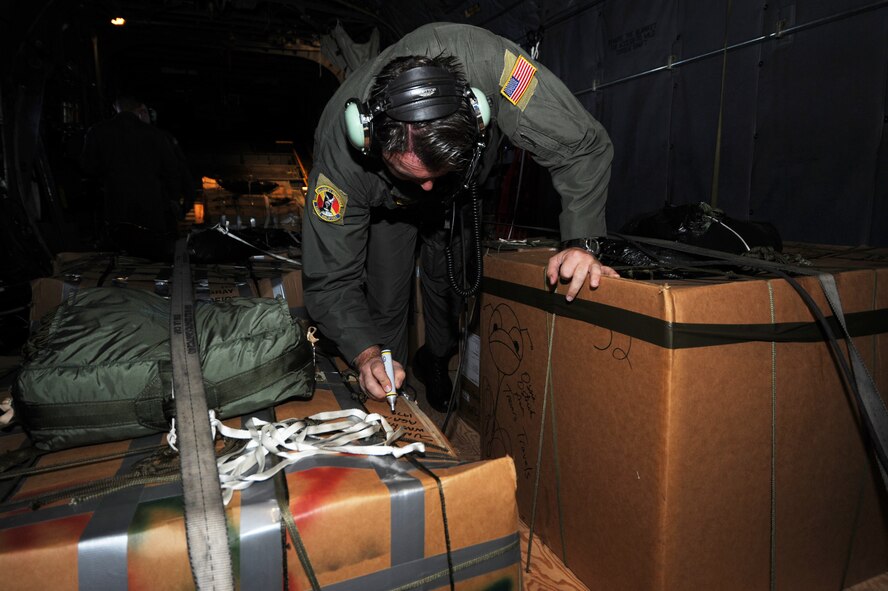 Chief Master Sgt. Michael Sundberg writes a holiday greeting on a pallet of goods to be dropped from a C-130 Hercules, Dec.19 during Operation Christmas Drop. Airmen today continue the tradition, delivering supplies to remote islands of the Commonwealth of the Northern Marianas Islands, Yap, Palau, Chuuk and Pohnpei. Over 600 pounds of donated goods was dropped over the remote islands during the operation. Chief Sundberg is a loadmaster from the 36th Airlift Squadron, Yokota AB, Japan. (U.S. Air Force photo/ Master Sgt. Kevin J. Gruenwald) released