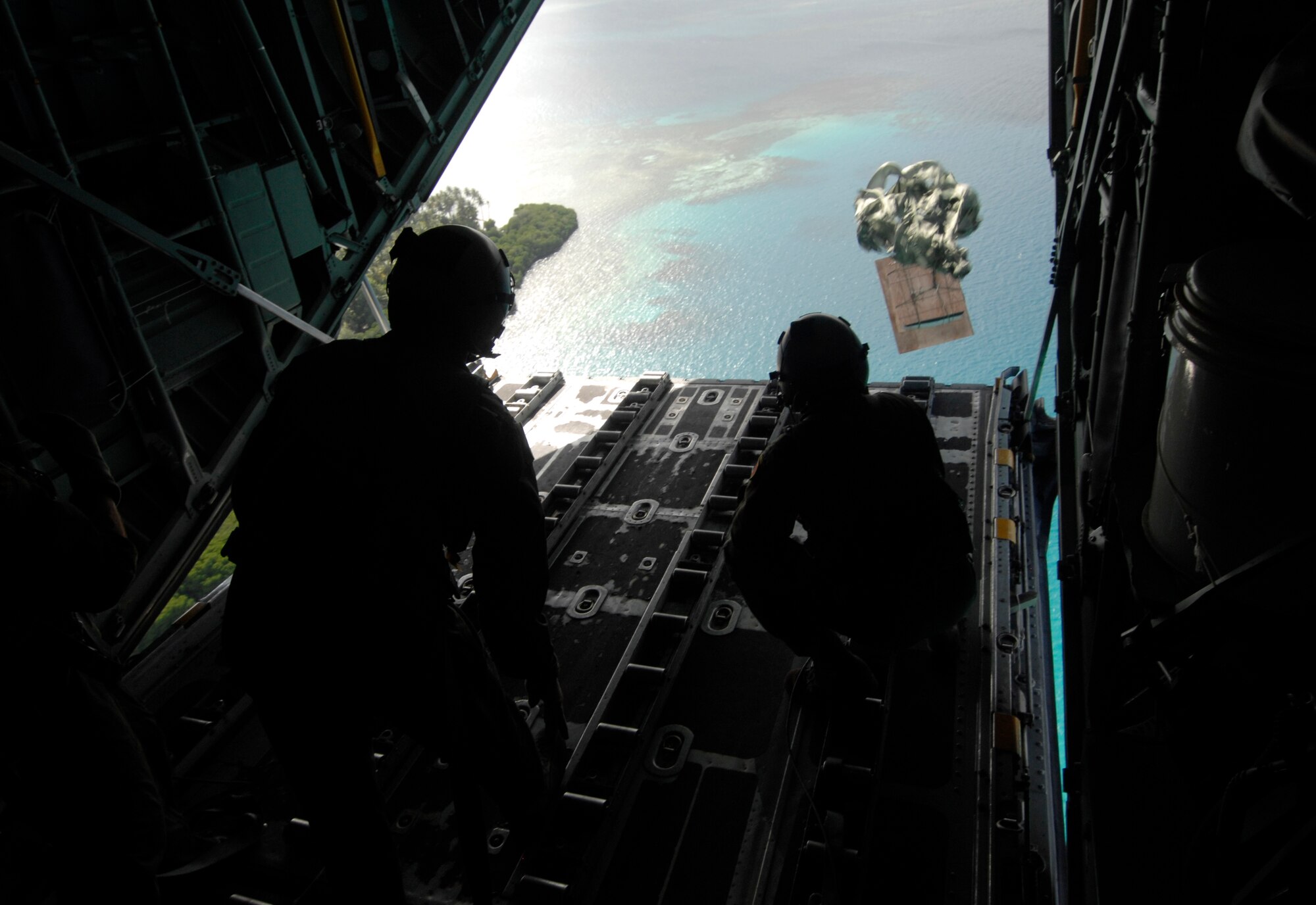 (left) Senior Airman Robert Gore and Airman 1st Class Dustin Deveaux push out a pallet of donated goods over the Islands of Chuuk, Dec. 19 from a C-130 Hercules during Operation Christmas Drop. In all, more than 180 boxes were built for the humanitarian mission, making 2008 one of the largest drops in Operation Christmas Drop's 57 year history. Airmen today continue the tradition delivering supplies to remote islands of the Commonwealth of the Northern Marianas Islands, Yap, Palau, Chuuk and Pohnpei. Both are loadmasters from the 36th Airlift Squadron, Yokota AB, Japan. (U.S. Air Force photo/ Master Sgt. Kevin J. Gruenwald) released