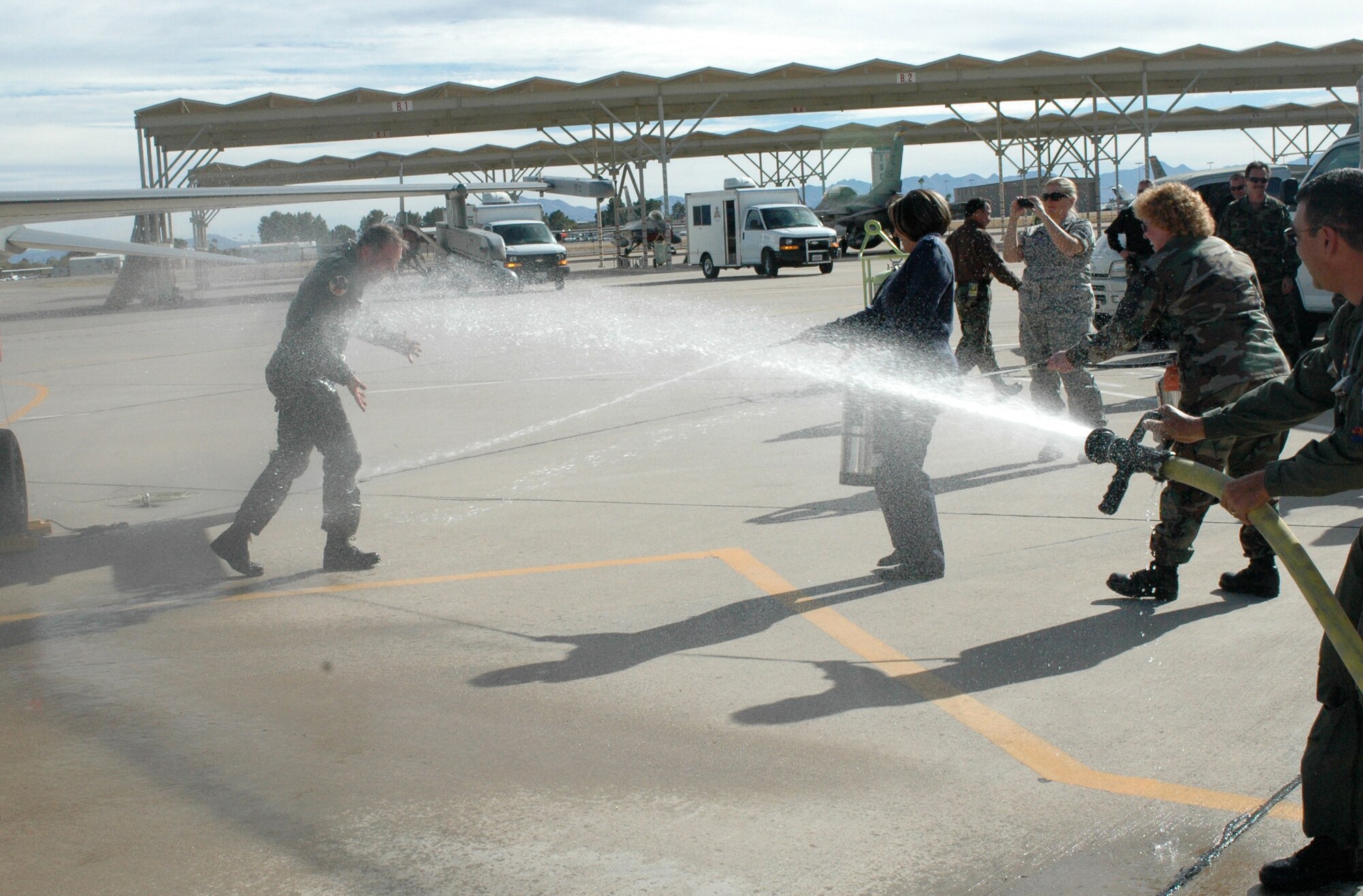 Brig. Gen. Rick Moisio, 162nd Fighter Wing commander, is hosed down by Master Sgt. Kerri Lane, Chief Master Sgt. Nikki Uremovich and Col. Jose Salinas after his final flight, or “fini” flight, here Dec. 19. The general is a command pilot with more than 30 years of experience and 6,000 flying hours mostly in fighter aircraft. He joined the 162nd in 1984 and assumed command of the unit in 2004. Following the fini flight, Guardsmen here held a farewell event for the commander who will depart the wing for another assignment in February. (Air National Guard photo by Capt. Gabe Johnson)
