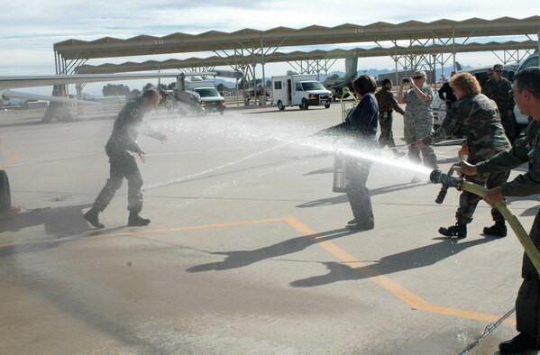 Brig. Gen. Rick Moisio, 162nd Fighter Wing commander, is hosed down by Master Sgt. Kerri Lane, Chief Master Sgt. Nikki Uremovich and Col. Jose Salinas after his final flight, or “fini” flight, here Dec. 19. The general is a command pilot with more than 30 years of experience and 6,000 flying hours mostly in fighter aircraft. He joined the 162nd in 1984 and assumed command of the unit in 2004. Following the fini flight, Guardsmen here held a farewell event for the commander who will depart the wing for another assignment in February. (Air National Guard photo by Capt. Gabe Johnson)
