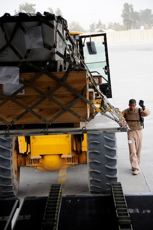 Senior Airman Anthony Johnson directs a forklift to the back of a C-17 Globemaster III so it can load cargo onto the aircraft Nov. 19 at Joint Base Balad, Iraq. Airman Johnson is an 816th Expeditionary Airlift Squadron loadmaster deployed from Charleston Air Force Base, S.C. He is a native of Columbus, Ga. (U.S. Air Force photo/Staff Sgt. Darnell T. Cannady) 
