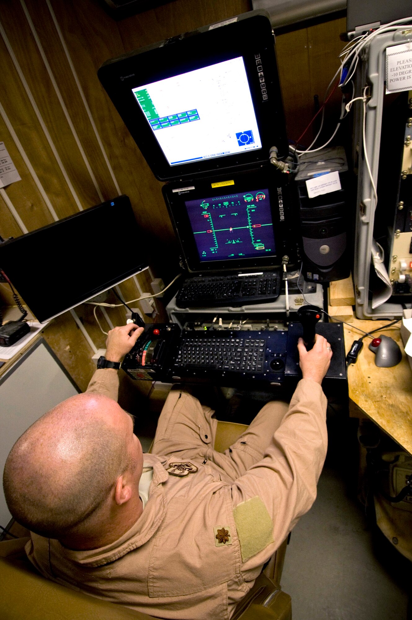 Maj. Rick Wageman operates the virtual cockpit of an MQ-1 Predator Oct. 25 at a base in southern Afghanistan. The remote nature of the control allows the Predator to stay airborne for longer periods of time, changing pilots periodically to reduce stress and fatigue which can lead to mission failure. Major Wageman is a 62nd Expeditionary Reconnaissance Squadron pilot deployed from Cannon Air Force Base, N.M. (U.S. Air Force photo/Staff Sgt. Samuel Morse) 
