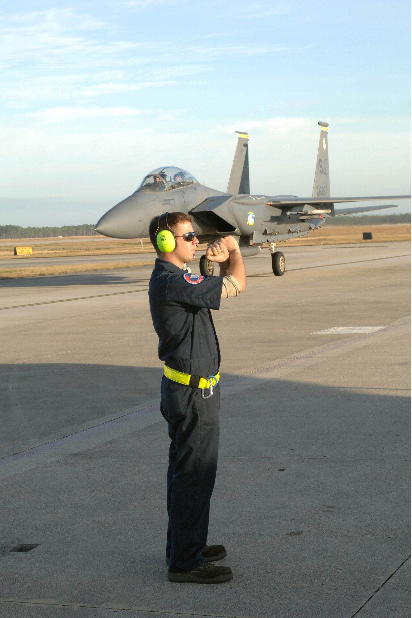 Airman 1st Class Justin Barber, a 336th Aircraft Maintenance Unit crew chief, marshals an F-15E Strike Eagle to a stop while another passes behind him on the taxi way at Tyndall Air Force Base, Fla. The 336th Fighter Squadron and associated maintenance personnel returned Dec. 19 from the two week air-to-air combat evaluation called Combat Archer. (U.S. Air Force photo by Staff Sgt. Shawn J. Jones)