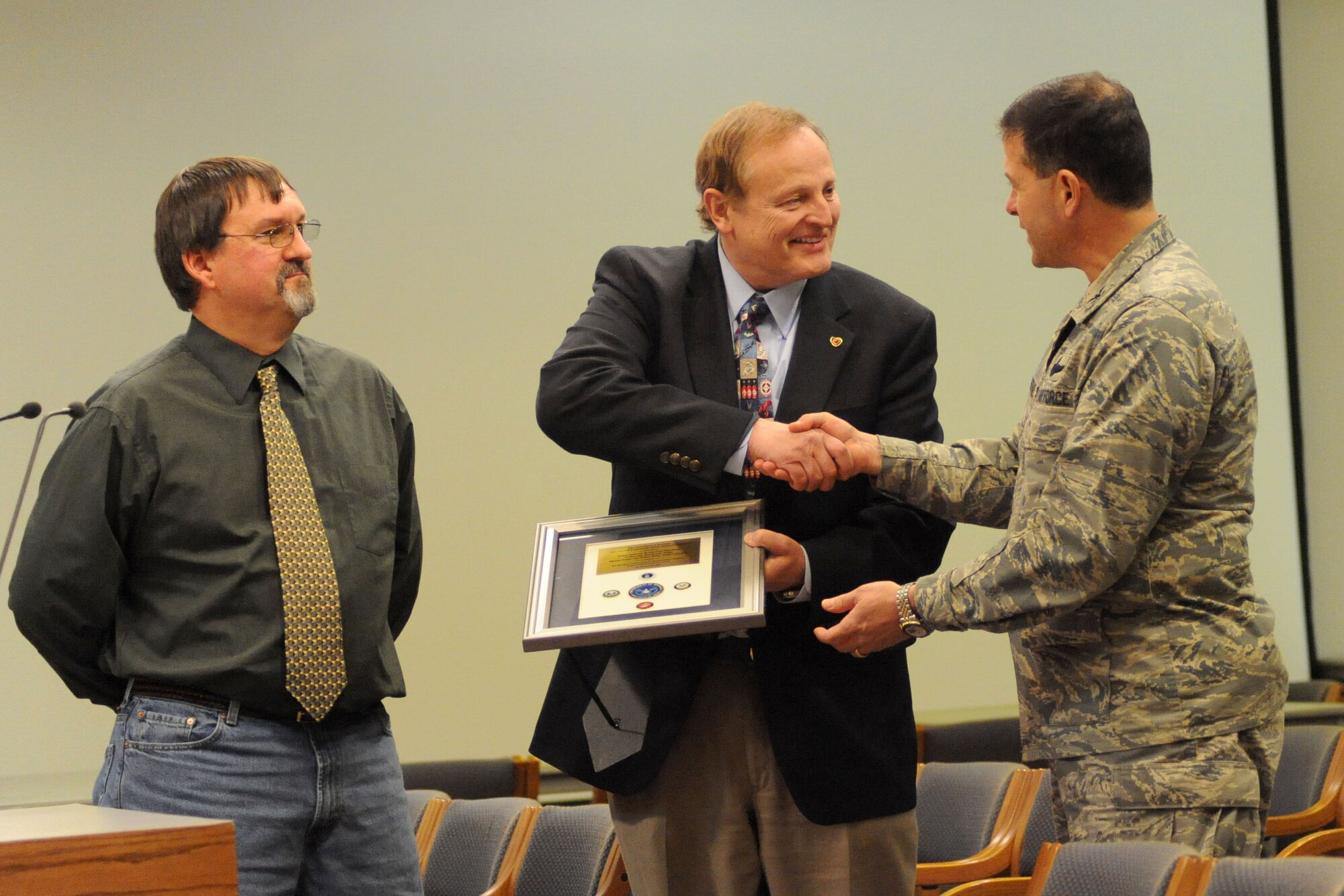 David Frisch (left), Demand Reduction Program manager, and Col. John Scorsone (right), 319th Air Refueling Wing vice commander, present Mayor Michael Brown, Grand Forks,  with the 18th Annual Secretary of Defense Community Drug Awareness Award. The wing credits the program's success to active community involvement in Grand Forks and East Grand Forks. (U.S. Air Force photo/Tech. Sgt. Amanda Callahan)