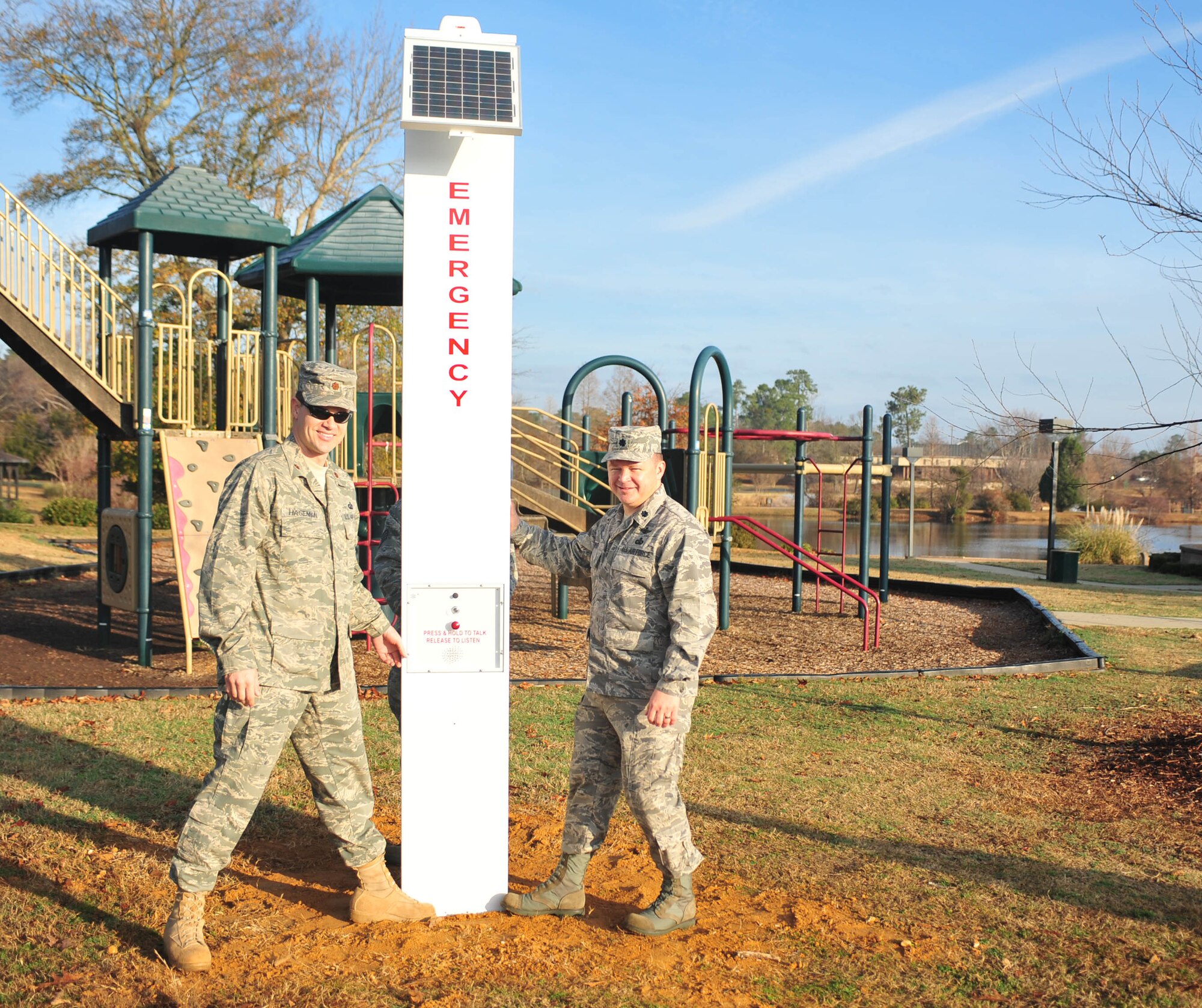 SHAW AIR FORCE BASE, S.C. -- Maj. James A. Hageman, 20th Contracting Squadron commander (left) and Lt. Col. Brian A. Wilkey, 20th Communication Squadron commander (right) stand alongside the new emergency system on Shaw AFB.  In case a caller is distressed, upon activation, a digitally stored voice will automatically transmit over the callbox radio channel to let responding personnel know the exact location of the callbox. (U.S. Air Force photo/Staff Sgt.Patrick Mitchell)