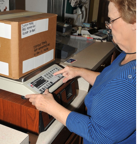 MOODY AIR FORCE BASE, Ga. -- Marilyn Osteen, base post office contractor, weighs a package at the base post office Dec. 18 here. Postal workers must weigh letters and packages to ensure the correct postage is added before items can be shipped. (U.S. photo by Senior Airman Schelli Jones)