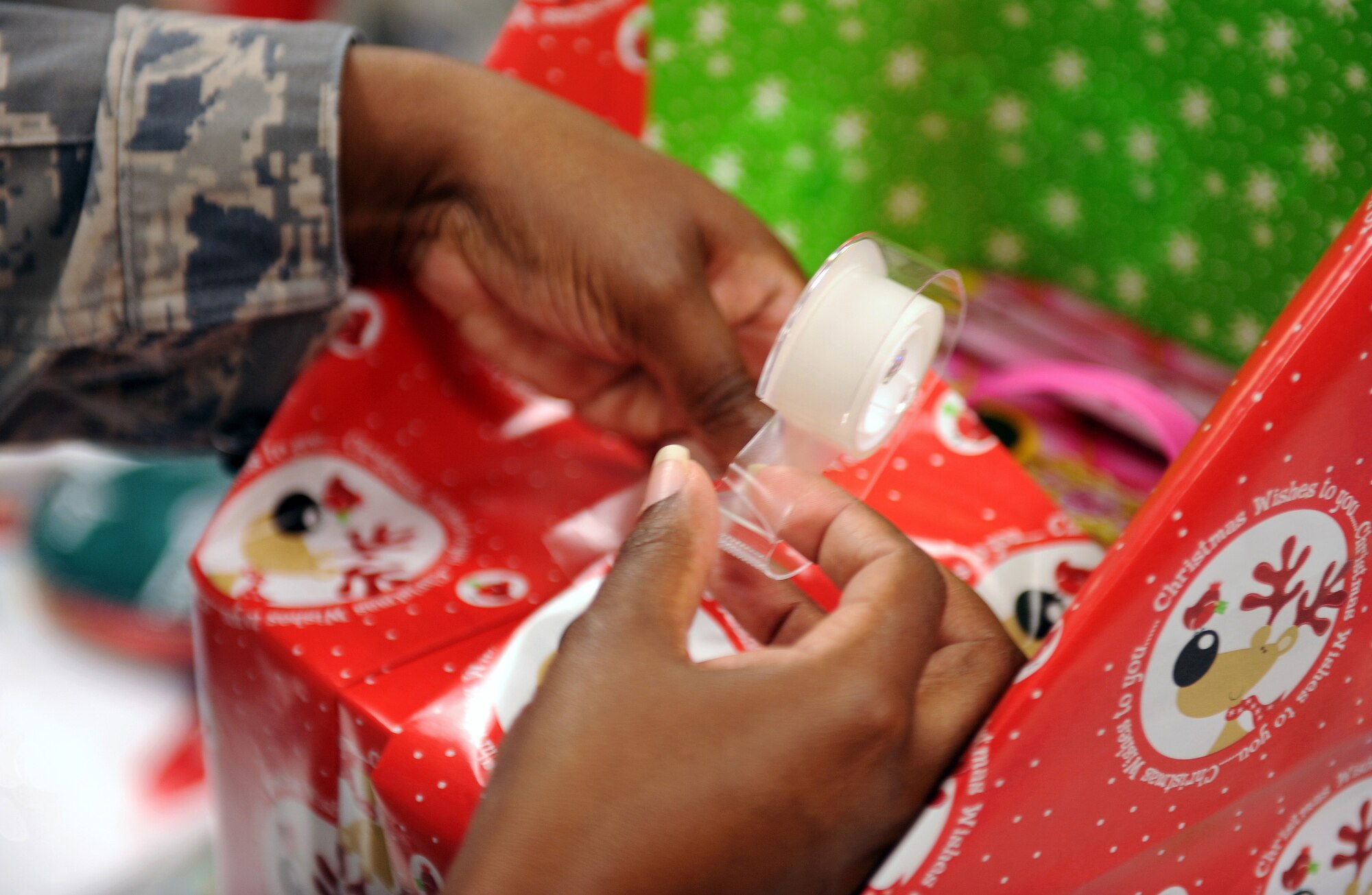 MOODY AIR FORCE BASE, Ga. -- Senior Airman Stacey Jeffrey, 23rd Mission Support Group knowledge operator, puts the finishing touches on a wrapped gift for a little girl during the Adopt-a-Family event at the Chapel Dec. 18 here. All Airmen and civilians that supported the event volunteered their time to help the underprivileged during this holiday season. (U.S. Air Force photo by Airman Joshua Green)