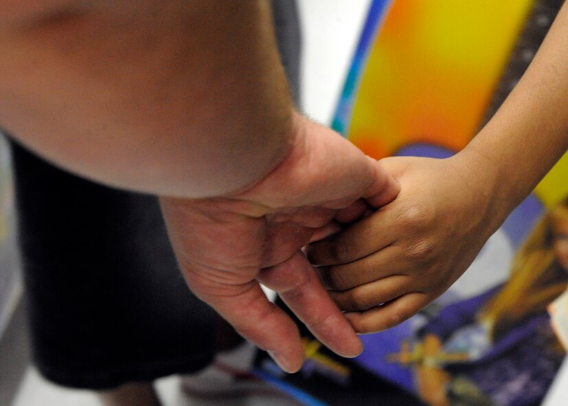 MOODY AIR FORCE BASE, Ga. -- Arman Coplan, a 2nd grader at Sallas-Mahone Elementary School, leads Capt. Jarett Biggers, 74th Fighter Squadron A-10C Thunderbolt II pilot, through a toy aisle in Valdosta, Ga., Dec. 18. Captain Biggers is a volunteer for the program which pairs military members and police officers with children to help them shop for presents. (U.S. Air Force photo by Senior Airman Brittany Barker) 