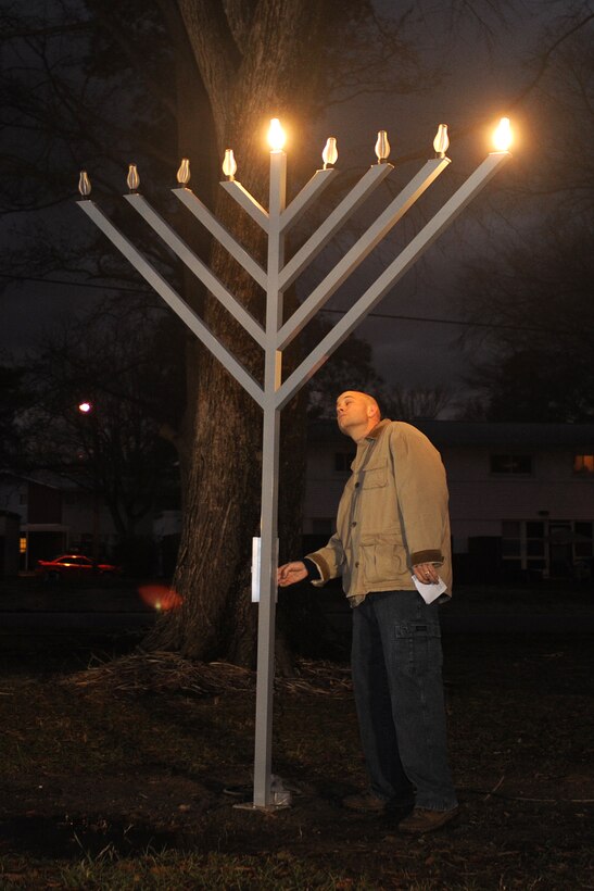 LANGLEY AIR FORCE BASE, Va.- Chaplin (Capt.) Clifford Jones lights the menorah during the annual Menorah lighting ceremony Dec 21. The Menorah is a symbol of the Hanukkah miracle in which a day's worth of oil burned for eight days and nights. During the celebration of Hanukkah, one candle is lit on each of the eight nights. (U.S. Air Force photo/Airman 1st Class Gul Crockett)