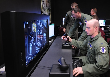 First Lt. Bret Saubert (right), 563rd Flying Training Squadron UAS student pilot, learns to integrate air power on a cyber-based simulation in the training lab at the UAS Fundamentals Course. (photo by Rich McFadden)