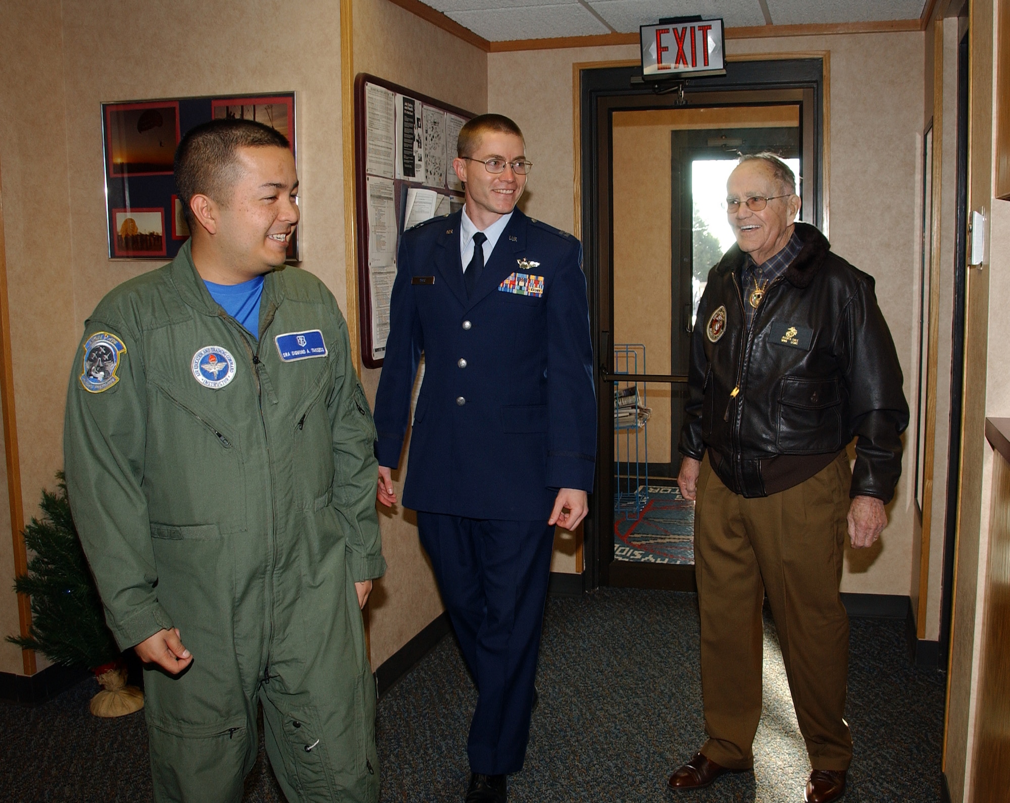 WWII veteran Mr. John R. Dale, right, and his escort Capt. Jeremy Rose, center, arrive for their tour of the Vance Air Force Base Aerospace Physiology Training building and are greeted by Senior Airman Sigmund Tanseco on Dec. 19. (U.S. Air Foce photo by 2nd Lt. Lynn Aird)