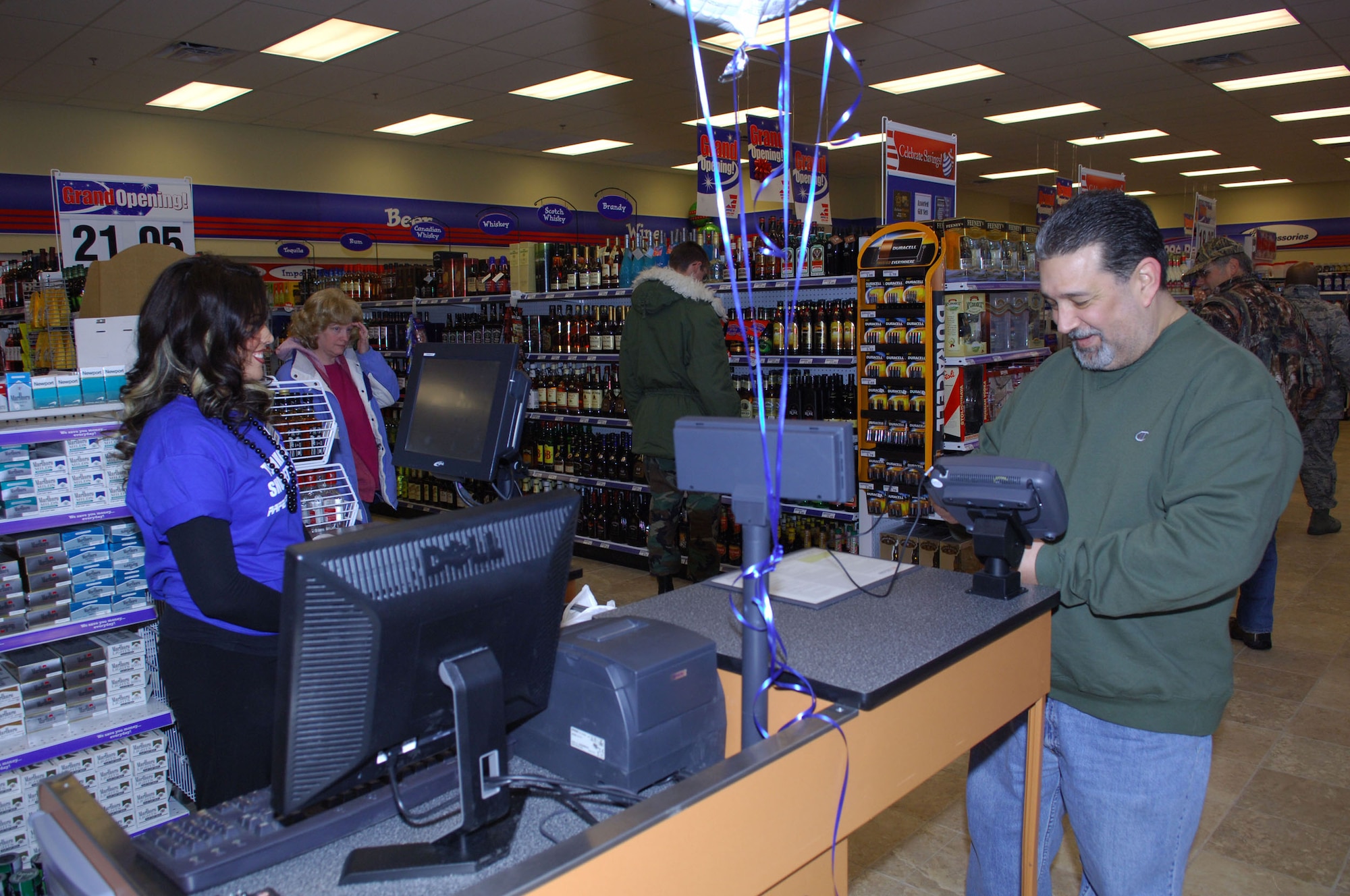 MINOT AIR FORCE BASE, N.D. -- Mr. John Metzigian, a strategic command trainer with the 91st Missile Maintenance Squadron here, is one of the first customers to pass through the checkout stand following the grand opening ceremony for the new base shoppette here Dec. 19. The new, state-of-the-art $17 million facility is more than 19, 000 square feet and includes 24-hour operation, a replacement of the existing AAFES service station and an AAFES-operated car wash. (U.S. Air Force photo by Senior Airman Cassandra Jones)
