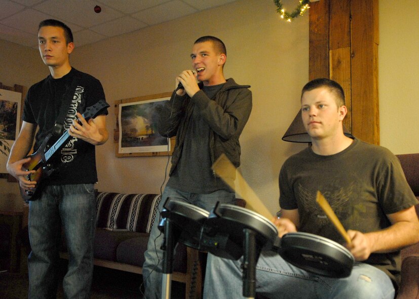 (From left) Airman 1st Class Brenndon Calhoun, 56th Logistics Readiness Squadron, Airman 1st Class Jonathan Santana, 56th Aircraft Maintenance Squadron, and Airman 1st Class Curtis Stepp, 56th Equipment Maintenance Squadron, play Rock Band 2 during the Best Buy Game Night held at the Oasis Building 542 Dec. 19.  (U.S. Air Force photo/Airman 1st Class Ronifel Yasay)