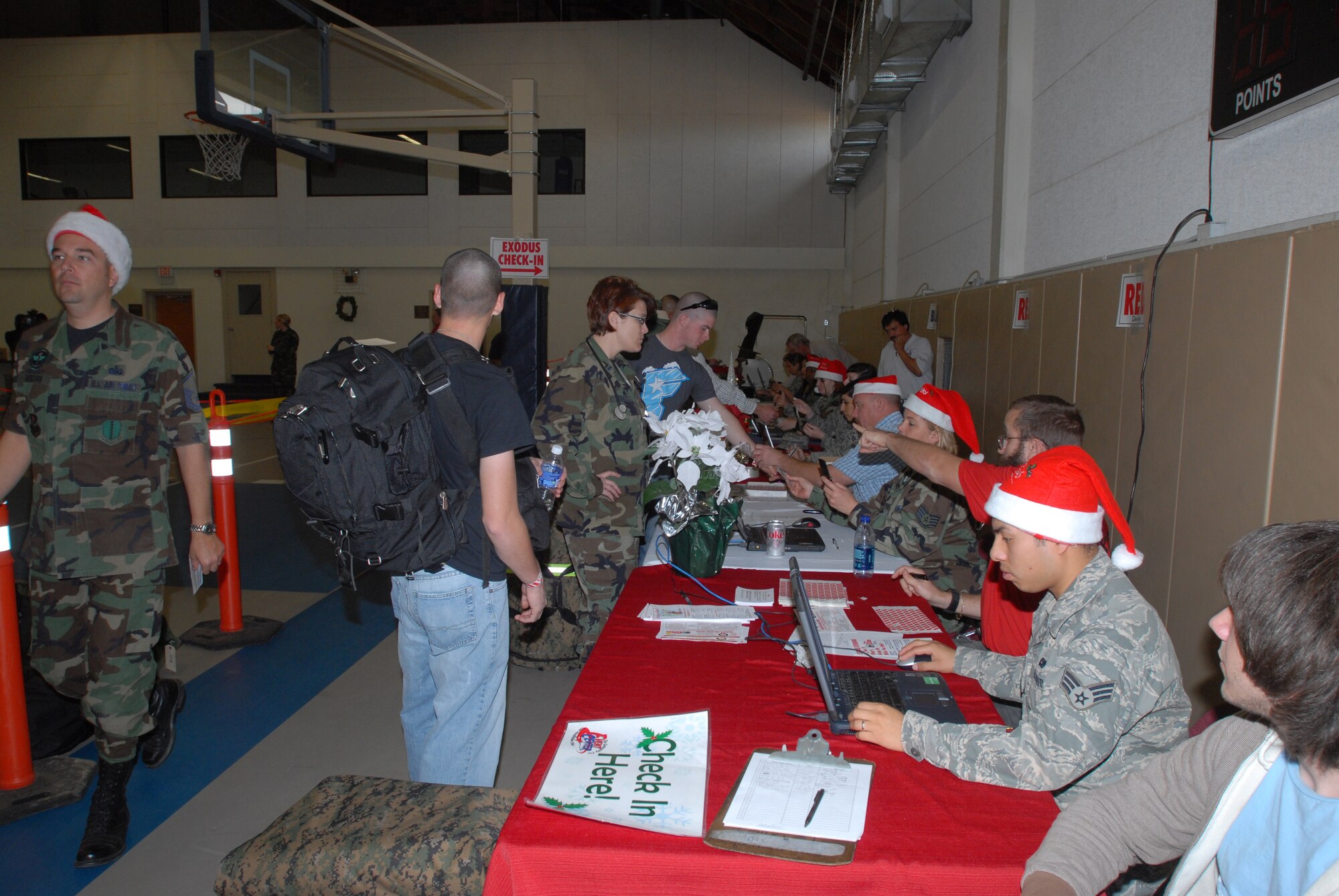 Servicemembers go through the line at the Carswell Field House on Dec. 19 to in process their luggage and check in for their respective buses Friday evening. More than 900 of the student servicemembers from Goodfellow Air Force Base, Texas, were scheduled to begin their journeys home via bus travel to surrounding-area airports as part of the base’s Holiday Exodus program. The Holiday Exodus program allows Goodfellow students to enjoy a two-week break from technical training during the winter holiday season. (U.S. Air Force photo by Paul Martin)