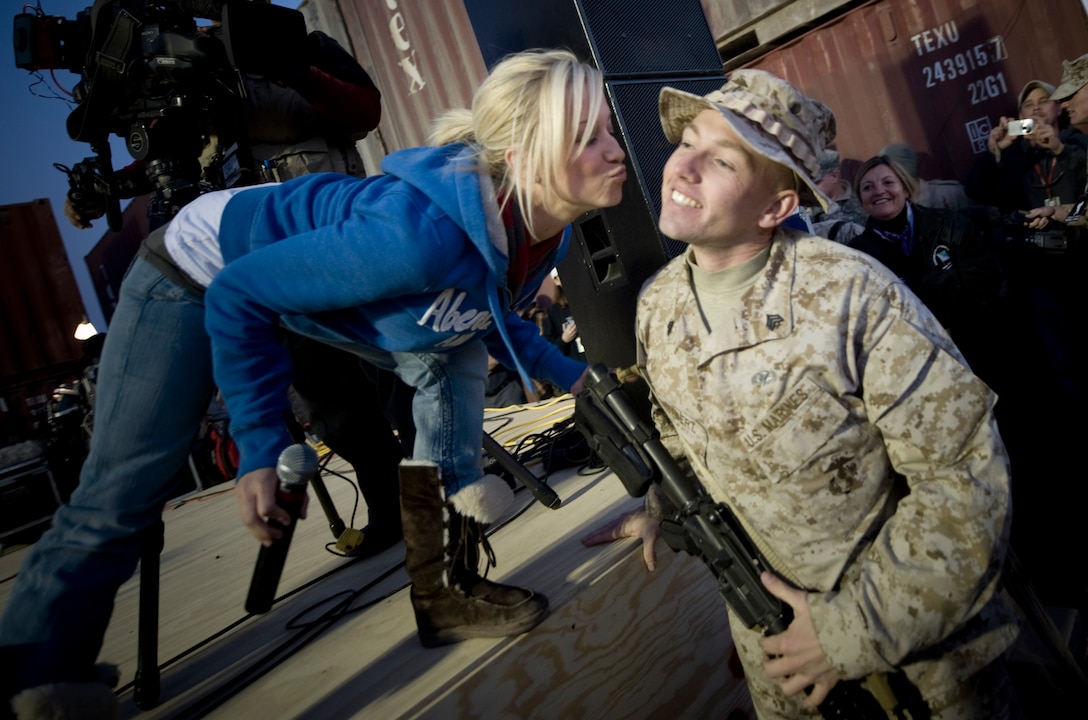 American Idol contestant and country musician Kellie Pickler grants a Christmas wish for a kiss to U.S. Marine Sgt. Christopher Lambert at the 2008 USO Holiday Tour stop at Al Asad Air Base, Iraq, Dec. 19, 2008.