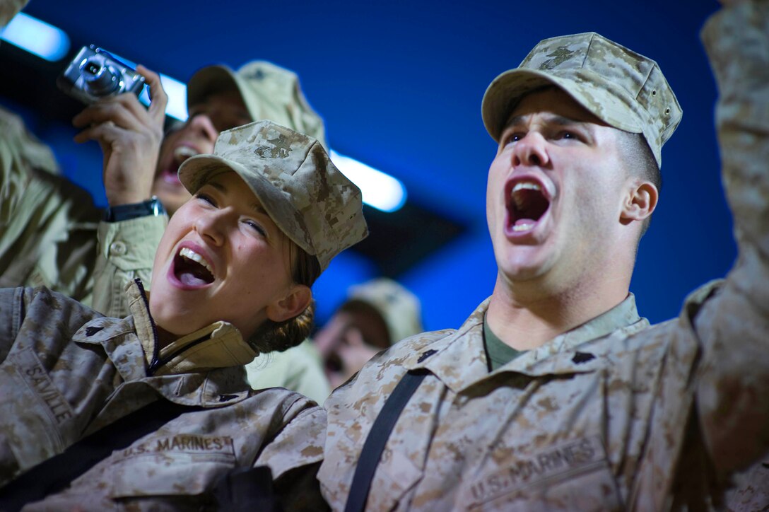 U.S. Marine Corps Cpl. Chantel Saville (left) and Sgt. Jonathan Oaks cheer at the introduction of  Grammy award-winning musician Kid Rock and Zac Brown during the 2008 USO Holiday Tour stop at Al Asad Air Base, Iraq, Dec, 19, 2008.