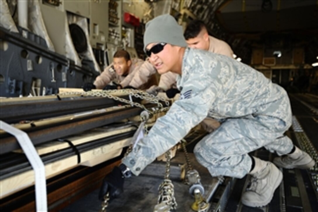 U.S. Air Force Staff Sgt. Zeus Lee pushes a palette of cargo from a C-17 Globemaster III onto a 60K loader at Joint Base Balad, Iraq, on Dec. 14, 2008.  Lee is a load crew team chief from the 332nd Expeditionary Logistics Readiness Squadron.  