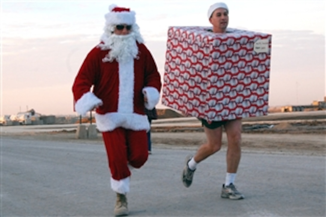 U.S. Army Sgt. Anthony Ward, dressed in the Santa suit, and 1st Lt. Philip Vrska, in the Christmas package, bring some holiday cheer to a 5K “Jingle” race sponsored on Camp Ramadi, Iraq, Dec. 20, 2008. Ward and Vrska are assigned to the 2nd Battalion, 9th Marine Regiment, Regimental Combat Team 1. While the festive pair didn’t place in the field of 64, they did complete the entire run in costume.