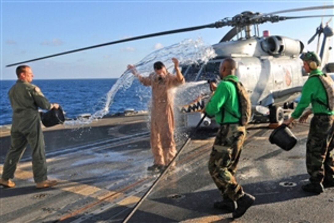 U.S. Navy Lt. Scott Miller is doused with water by U.S. Navy sailors aboard the guided-missile cruiser USS Vella Gulf, under way in the Indian Ocean, in celebration of his completion of 1,000 logged hours of flight time, Dec. 17, 2008. The sailors are assigned to Helicopter Anti-Submarine Squadron Light 42, Detachment 1. 