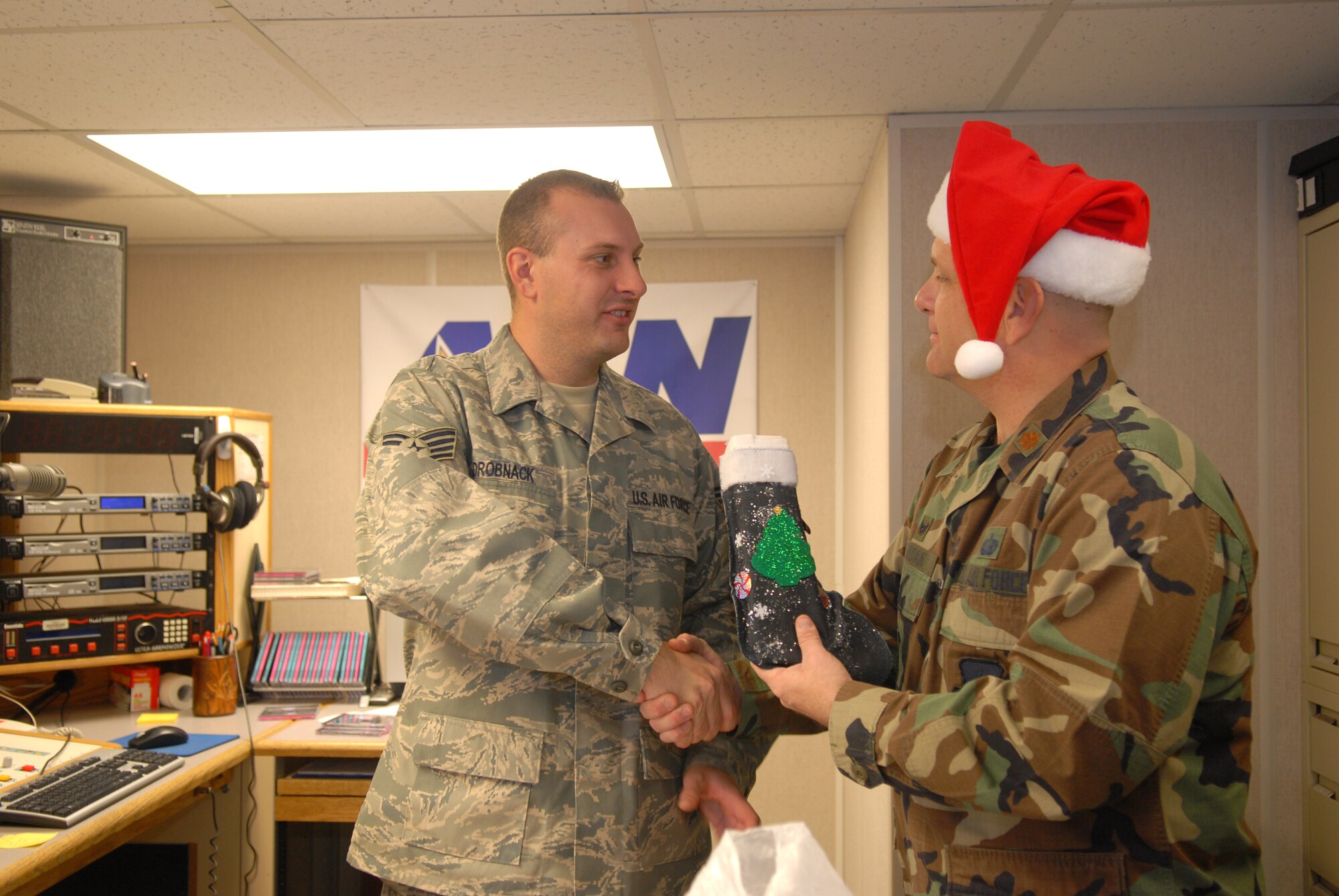 KUNSAN AIR BASE, Republic Of Korea -- Maj. Stephen Jordan 8th Force Support Squadron commander, delivers cookies and stockings to Staff Sgt. Aaron Drobnack, American Forces Network Kunsan, Dec. 24. Ms. Dona Neusbaum, mother of a former Wolf Pack member,  along with citizens of Lubbock, Texas, sent hand-made Christmas stockings and other gifts to every Airman at Kunsan. (U.S. Air Force photo by: Senior Airman Angela Ruiz)