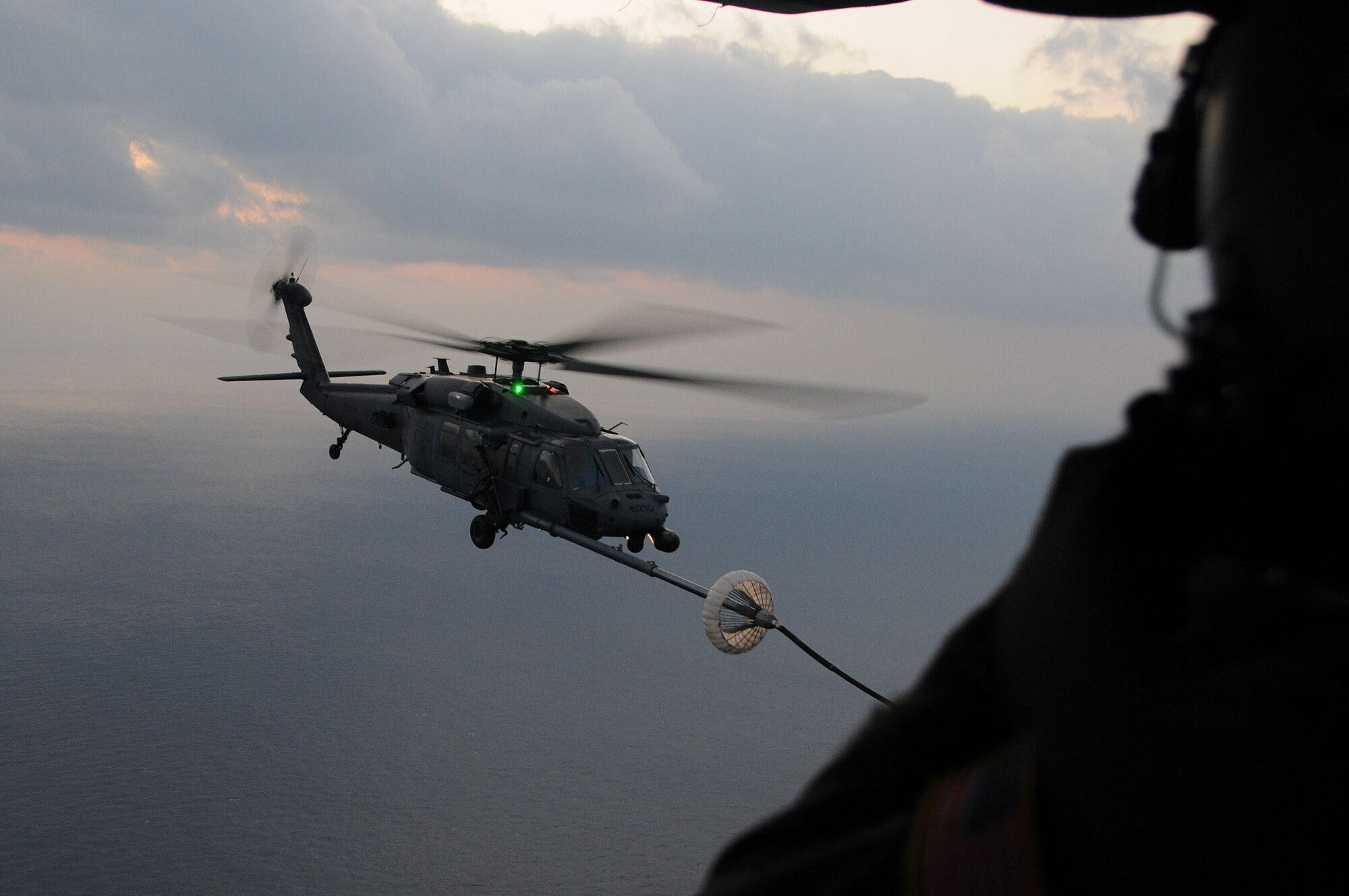 A loadmaster from the 17th Special Operations Squadron watches as an HH-60 from the back door of an MC-130P as an HH-60 Pave Hawk helicopter is refueled. The 17th SOS flew 21 Pararescue Airmen assigned to the 31st Rescue Squadron and refueled two HH-60s from the 33rd Rescue Squadron during a training mission Dec. 16, 2008. (U.S. Air Force photo/Staff Sgt Chrissy Best)
