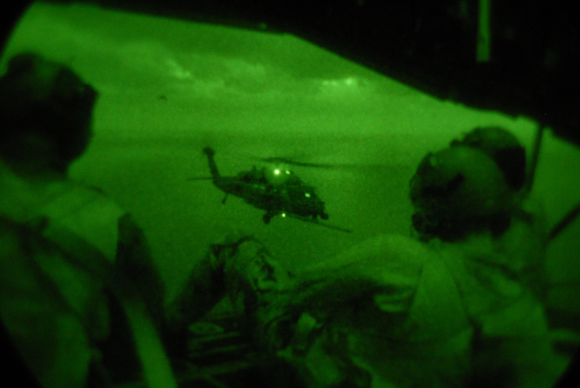 Loadmasters and crew from the 17th Special Operations Squadron at Kadena Air Base, Japan watch out the back door of an MC-130P as an HH-60 Pave Hawk helicopter receives fuel. The 17th SOS flew 21 Pararescue Airmen assigned to the 31st Rescue Squadron, and refueled two HH-60s from the 33rd Rescue Squadron during a training mission Dec. 16, 2008. (U.S. Air Force photo/Staff Sgt Chrissy Best) 