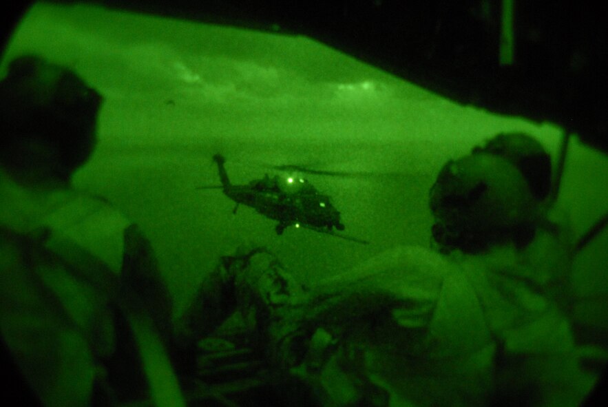 Loadmasters and crew from the 17th Special Operations Squadron at Kadena Air Base, Japan watch out the back door of an MC-130P as an HH-60 Pave Hawk helicopter receives fuel. The 17th SOS flew 21 Pararescue Airmen assigned to the 31st Rescue Squadron, and refueled two HH-60s from the 33rd Rescue Squadron during a training mission Dec. 16, 2008. (U.S. Air Force photo/Staff Sgt Chrissy Best) 