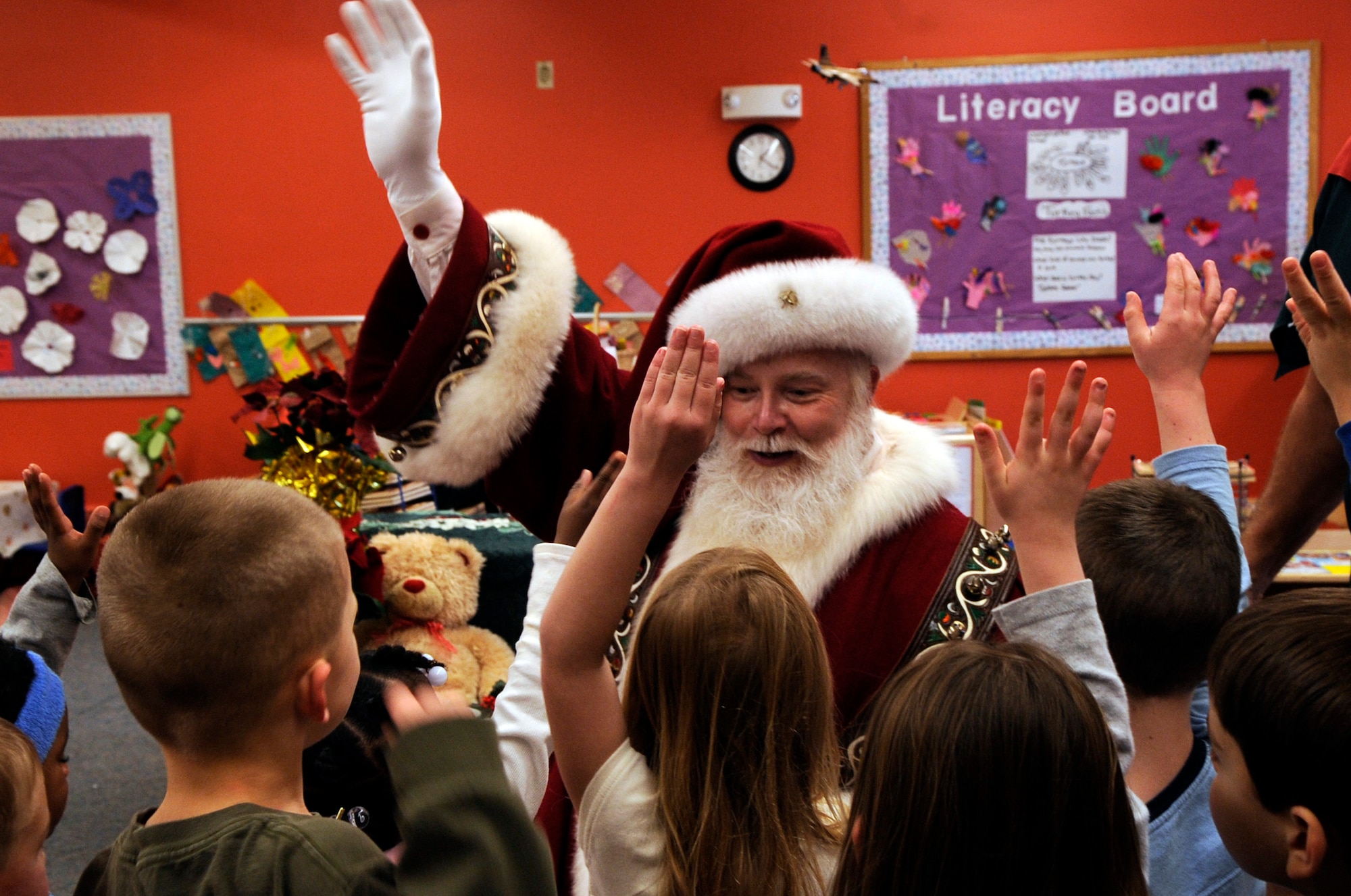 Santa Claus tells children to raise their hand if they have been a good boy or girl during a surprise visit to a child development center Dec. 23 at Peterson Air Force Base, Colo. (U.S. Air Force photo/Staff Sgt. Desiree N. Palacios) 