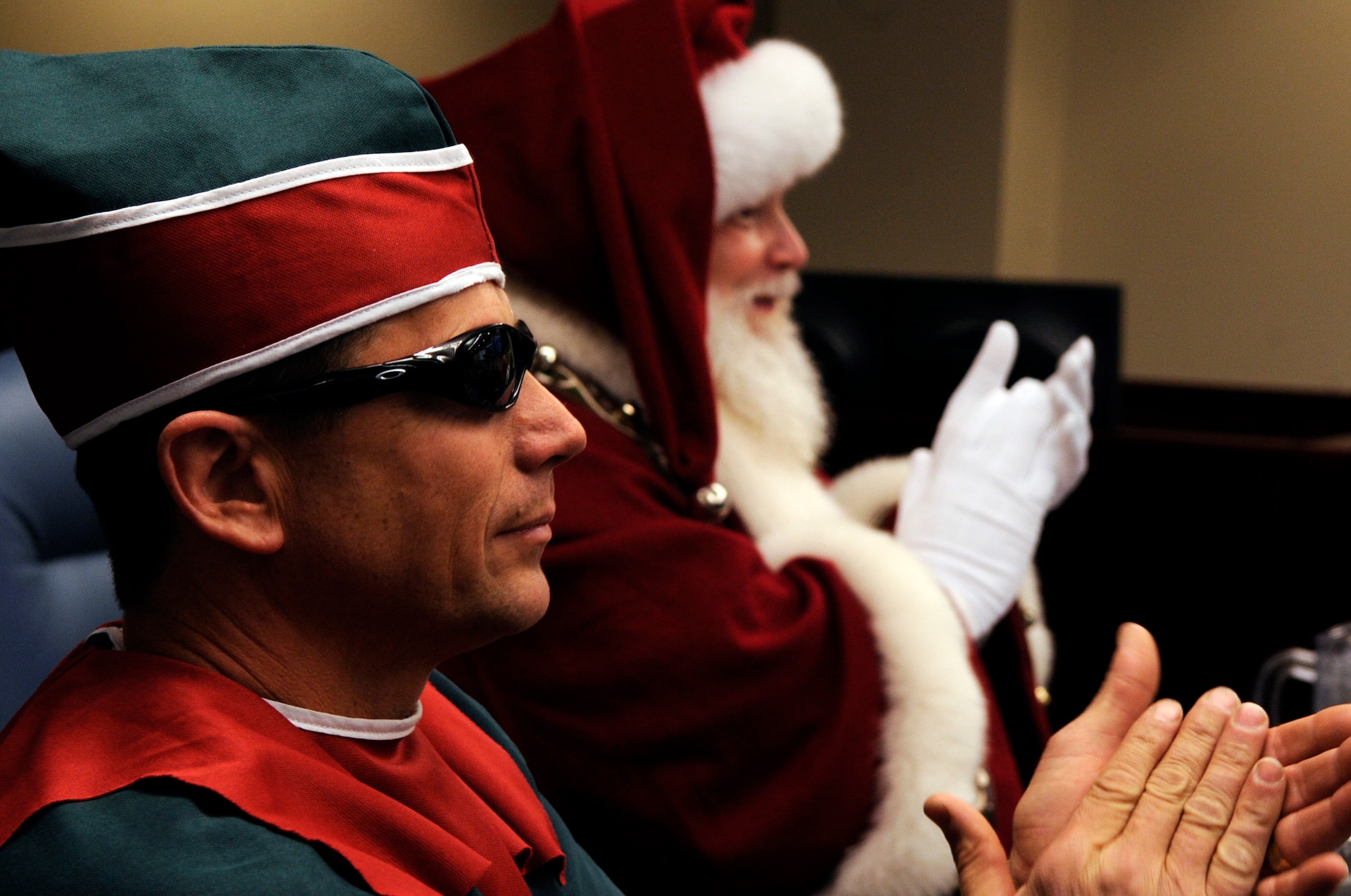 Santa Claus and Elf Dee make a surprise visit to the North American Aerospace Defense Command Tracks Santa Battle Cab Dec. 23 at Peterson Air Force Base, Colo. Santa received Federal Aviation Administration, weather and air mission briefs. (U.S. Air Force photo/Staff Sgt. Desiree N. Palacios) 