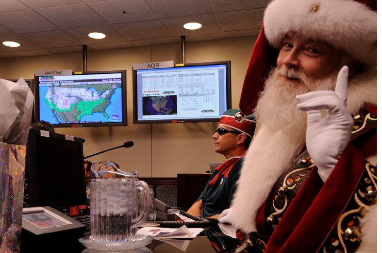 Santa Claus makes a surprise visit to the North American Aerospace Defense Command Tracks Santa Battle Cab Dec. 23 at Peterson Air Force Base, Colo. Santa received Federal Aviation Administration, weather and air mission brief. (U.S. Air Force photo/Staff Sgt. Desiree N. Palacios) 