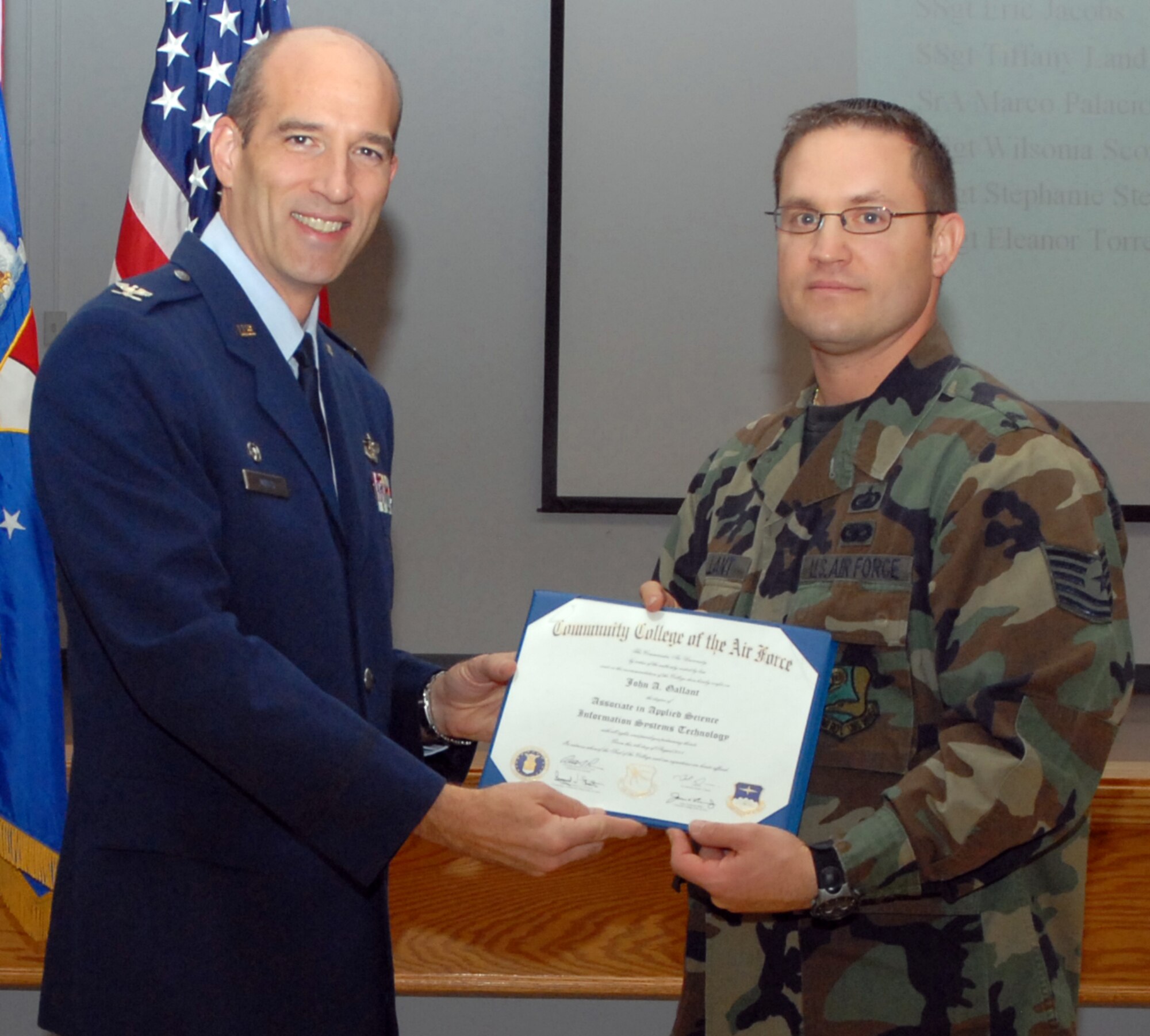 Air Force Reservist Tech. Sgt. John Gallant receives his Community College of the Air Force diploma from 940th Air Refueling Wing Commander Col. Jeffery "Sal" Mineo at the wing's commander's call December 7, 2008. Tech. Sgt. John Gallant was selected as the 940th ARW 2008 Non-Commissioned Officer of the Year.  (U.S. Air Force Photo/ Tech. Sgt. Luke Johnson)