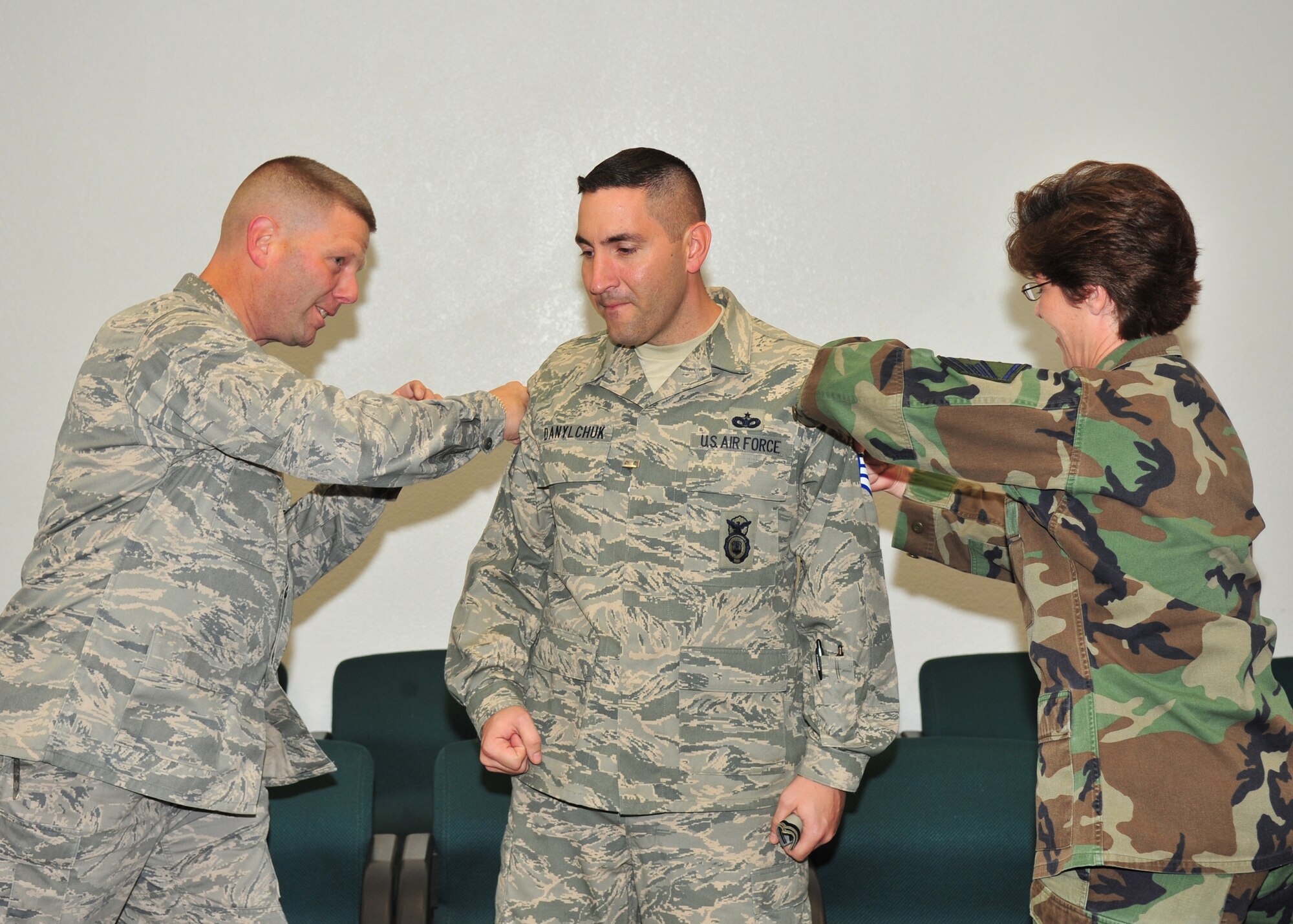 Maj. Christopher Johnson, 355th Security Forces Squadron commander, and  Master Sgt. Wendy Lee, 355th Security Forces Squadron First Sergeant, pin Master Sergeant stripes on STEP promotee Master Sgt. Robert Danylchuck, 355th Security Forces Squadron here, Dec. 23. (U.S. Air Force photo/Senior Airman Noah R. Johnson)