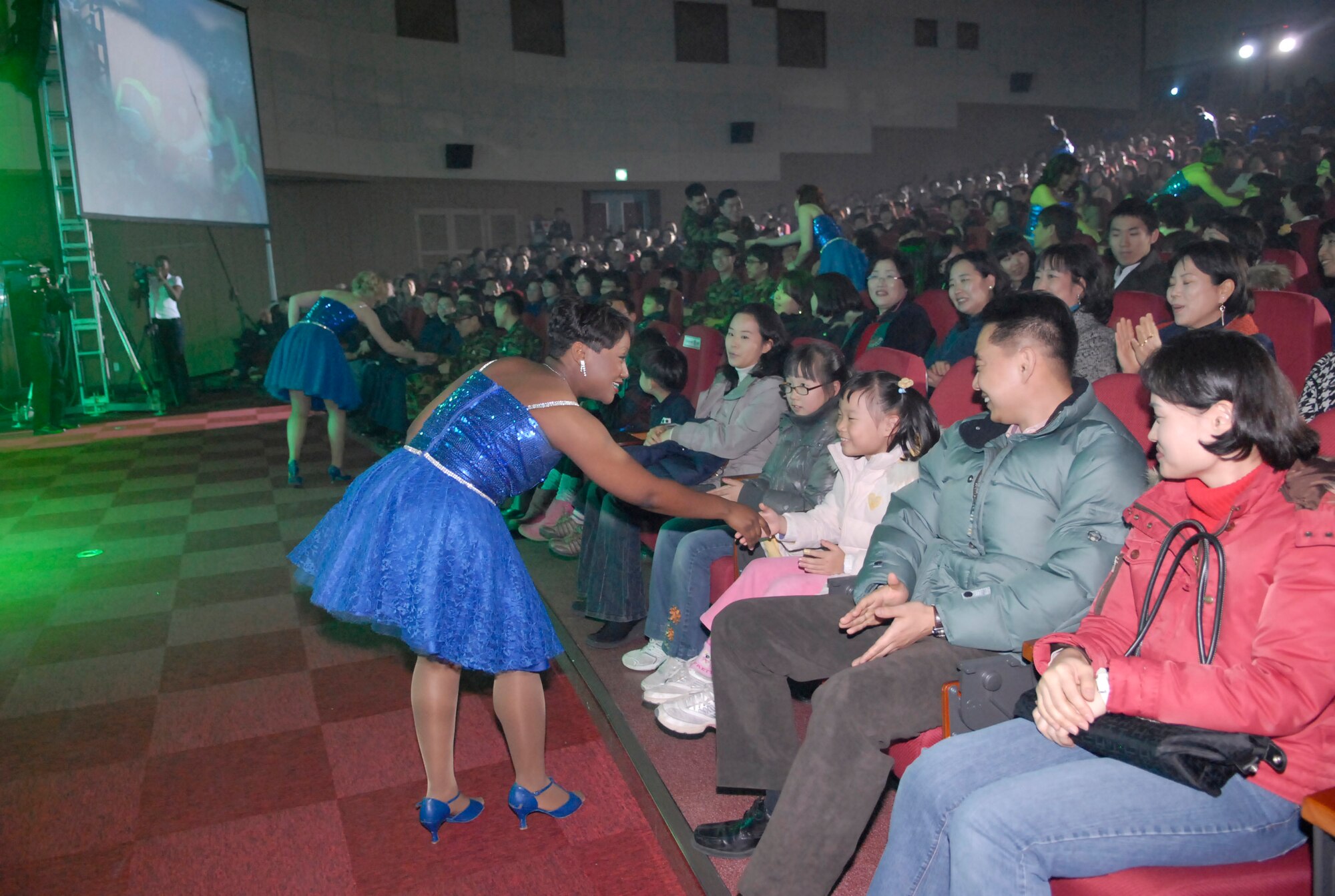 Airman 1st Class Alice Lewis greets the audience during a performance at the South Korean armed forces headquarters Dec. 19. The peformance was part of the year-long celebration of the 60th anniversary of the South Korean armed forces. Airman Lewis is a Tops In Blue member. (U.S. Air Force photo/Staff Sgt. Scottie McCord) 
