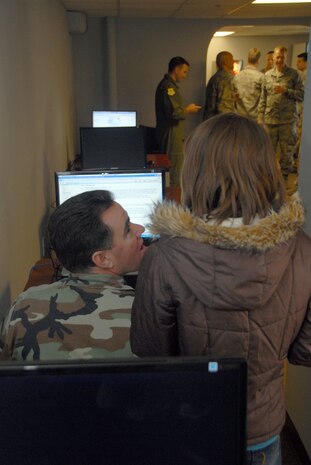 Master Sgt. Jeffrey Seder and his daughter, Anna, use the Internet on one of the new computers during the grand opening of the Dispersed Airmen?s Center on base Dec. 23. The Airmen Ministry Center/Internet Caf? was the first of four separate sections to open for the center. Sergeant Seder is a dorm manager assigned to the 437th Civil Engineer Squadron. 