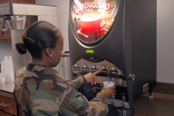 Airman 1st Class Brittney Kelly uses the cappuccino machine during the grand opening of the Dispersed Airmen?s Center on base Dec. 23. The Airmen Ministry Center/Internet Caf? was the first of four separate sections to open for the center. Airman Kelly is with the 437th Logistics Readiness Squadron. (U.S. Air Force photo/Airman 1st Class Melissa White)