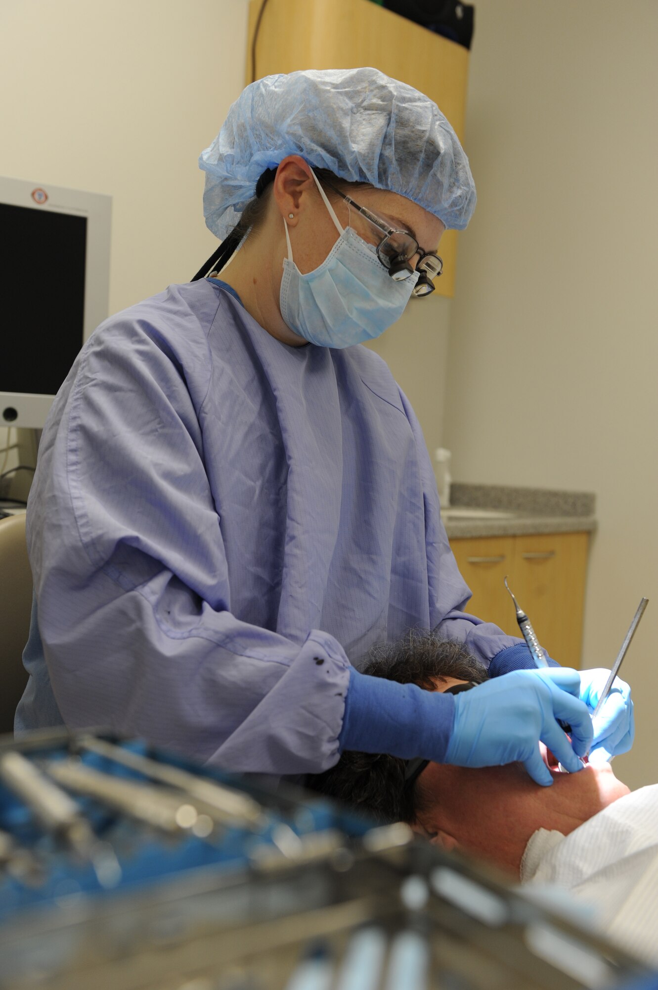 WHITEMAN AIR FORCE BASE, Mo. - Tech. Sgt. Crystal Jarvis, 509th Medical Group dental clinic dental hygienist, performs a routine cleaning on a patient, Dec. 15. Sergeant Jarvis uses different types of tools to ensure all plaque and any other foreign objects have been removed from teeth surface. (U.S.  Air Force photo/Airman 1st Class Carlin Leslie)
