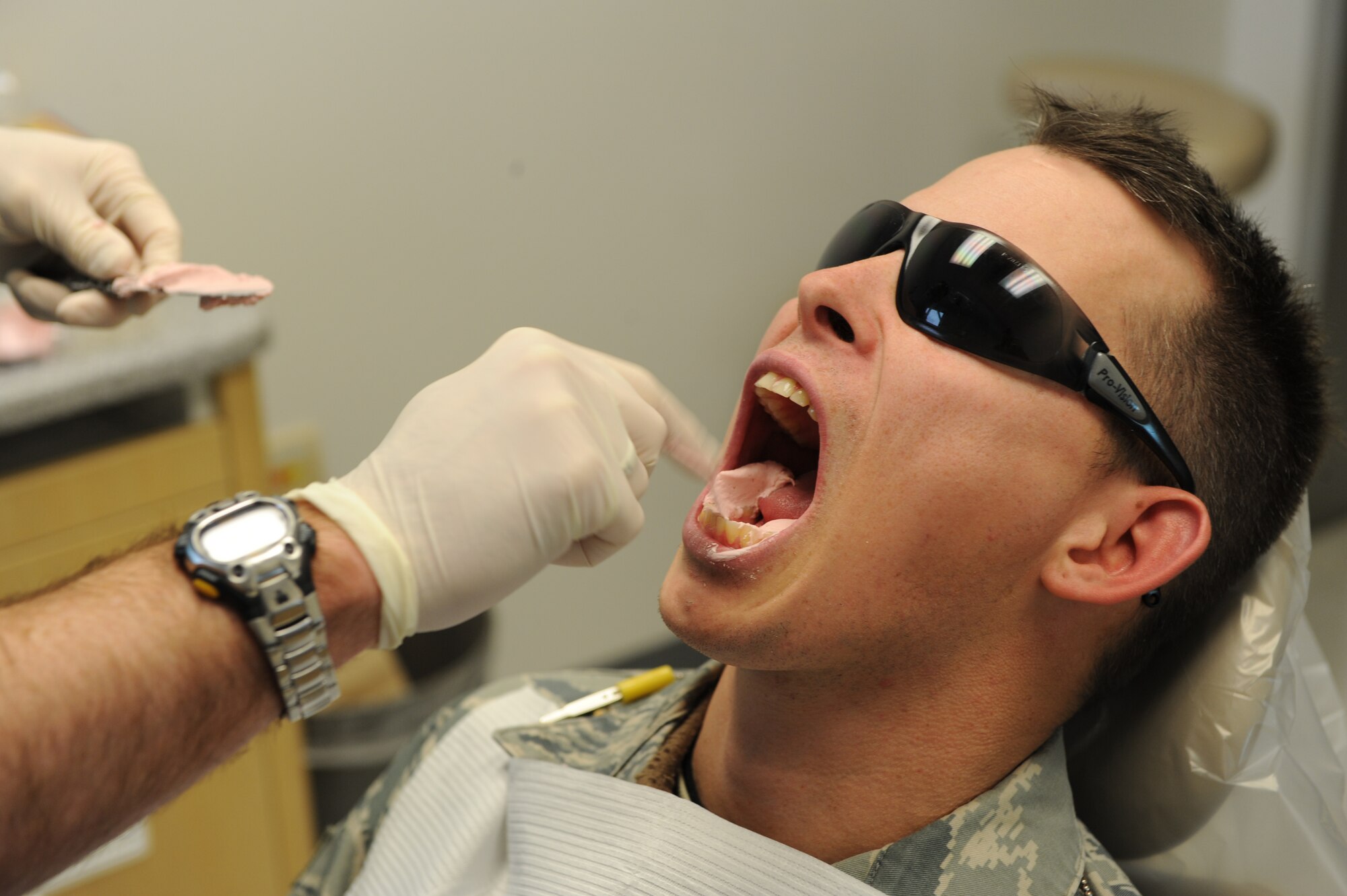 WHITEMAN AIR FORCE BASE, Mo. - Capt. Carl Bhend, 509th Medical Group dental clinic dentist, inserts molding paste into a patient?s mouth Dec. 15 during a training session. Captain Bhend inserts the paste by hand into the mouth before inserting the whole plate to ensure all gaps are filled to provide an accurate molding of the lower teeth. (U.S.  Air Force photo/Airman 1st Class Carlin Leslie)