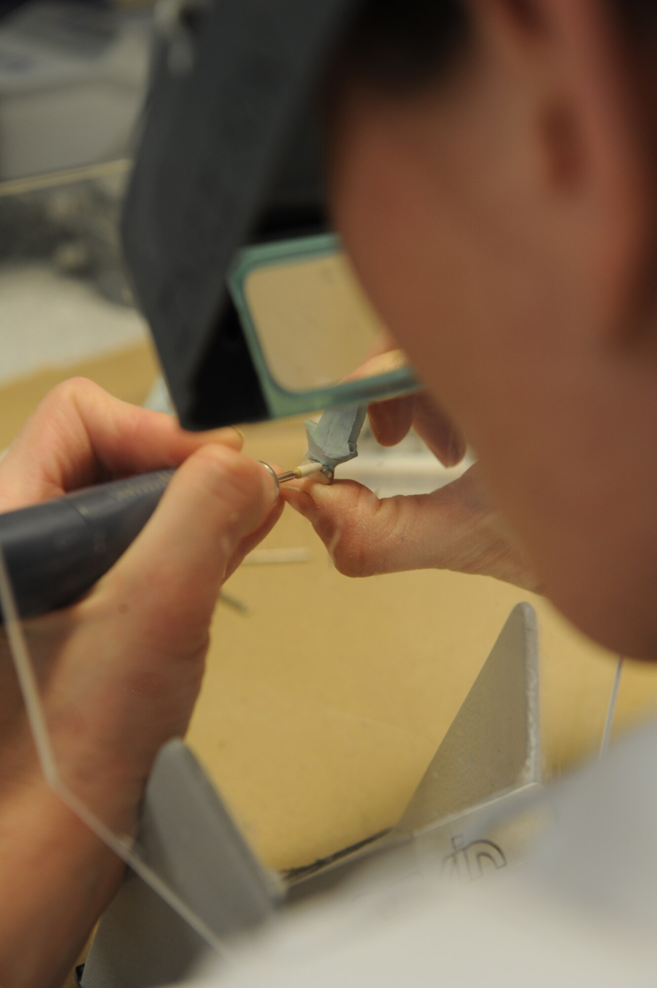 WHITEMAN AIR FORCE BASE, Mo. - Master Sgt. Julie Ingison, 509th Medical Group Dental Clinic technician, hand crafts a crown for a molar by slowly grinding down the edges with the dental drill Dec. 15. Sergeant Ingison crafts each crown to fit the shape of the old tooth to ensure an exact fit. The dental clinic averages six crowns per month and each crown can take between eight and 36 hours to create.  The dental clinic also creates a multitude of other oral devices including dentures. (U.S.  Air Force photo/Airman 1st Class Carlin Leslie)