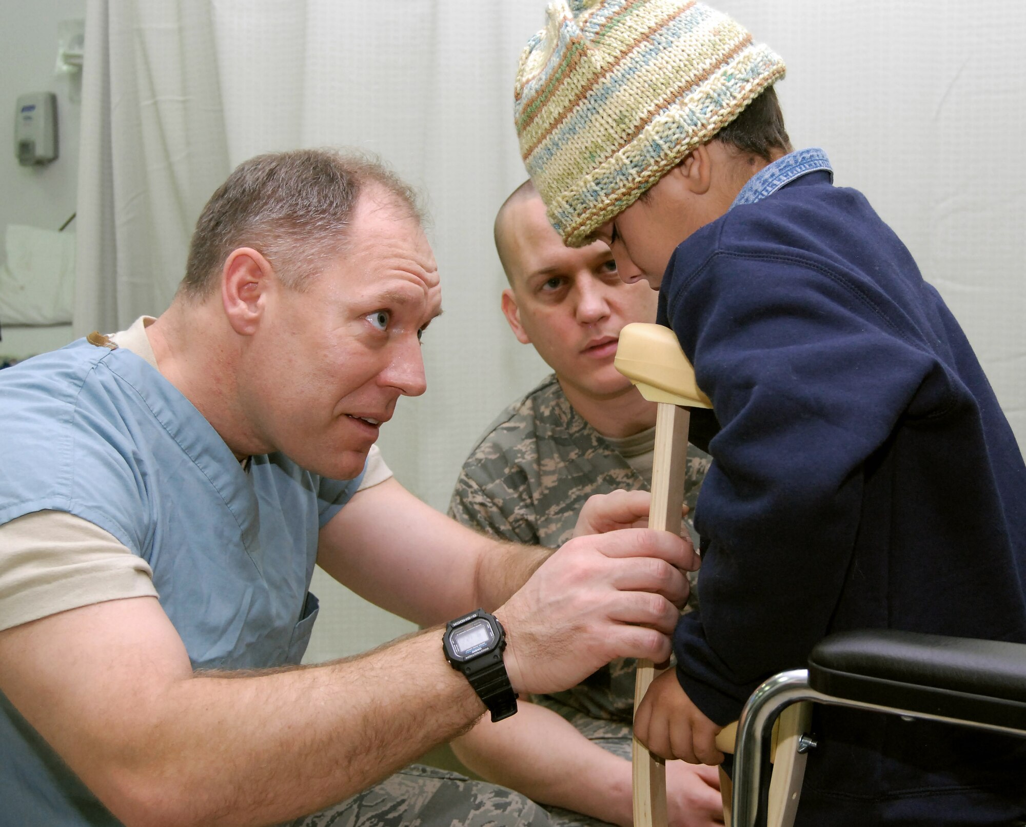 Lt. Col. Robert Burgess and Tech. Sgt. Richard Kemp help fit a pair of crutches for Mustafa Jasim in the Air Force Theater Hospital's intermediate care ward at Joint Base Balad, Iraq, Dec. 20. Colonel Burgess, a 332nd Expeditionary Medical Operations Squadron physical therapist, is deployed from Shaw Air Force Base, S.C.  Sergeant Kemp, a 332nd EMDOS medical technician, is deployed from Wilford Hall Medical Center at Lackland AFB, Texas. (U.S. Air Force photo/Staff Sgt. Don Branum) 