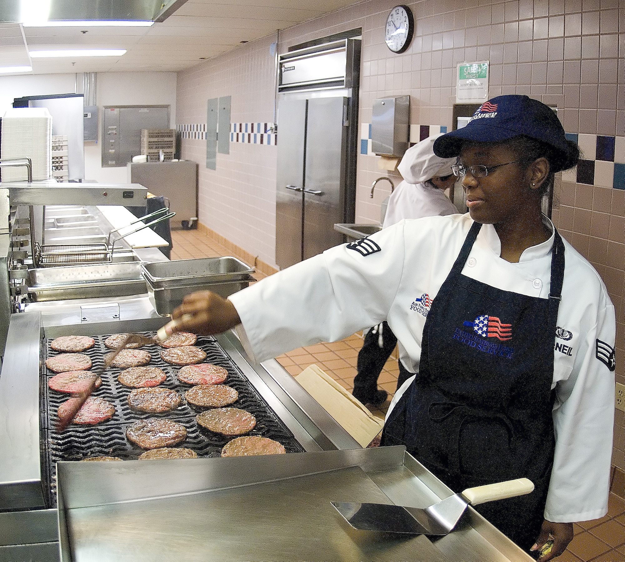 Senior Airman Ebony McNeil, 436th Services Squadron, cooks hamburger patties before the lunch time meal.