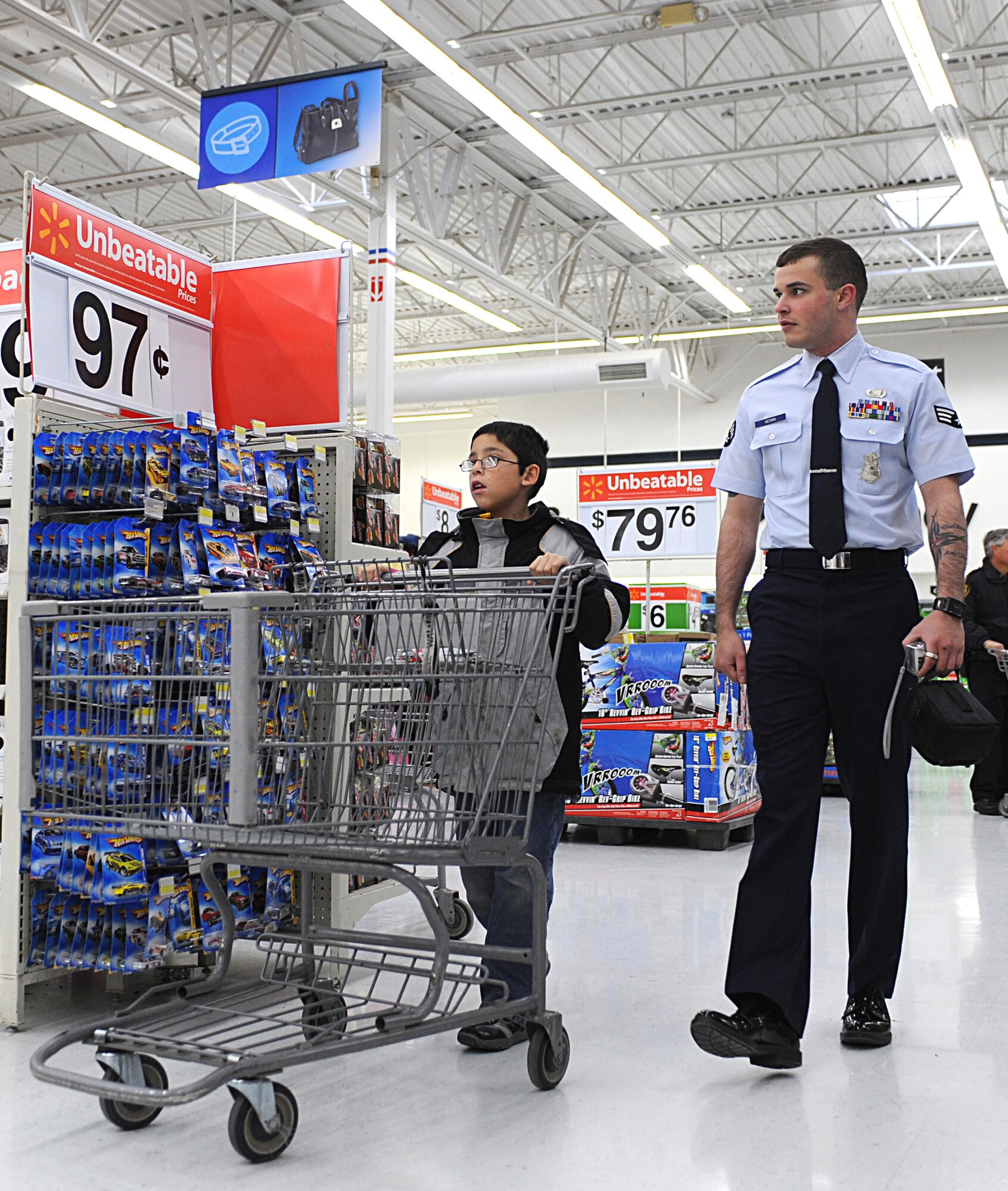 CANNON AIR FORCE BASE, N.M. -- Senior Airman Shawn Keown, 27th Special Operations Security Forces Squadron, helps a child shop during the Shop with a Cop event, Dec. 22. Cannon security forces Airmen participated in the annual program with local city police to help children spend a donated $100 gift card.. (U.S. Air Force photo/Airman 1st Class Evelyn Chavez)  