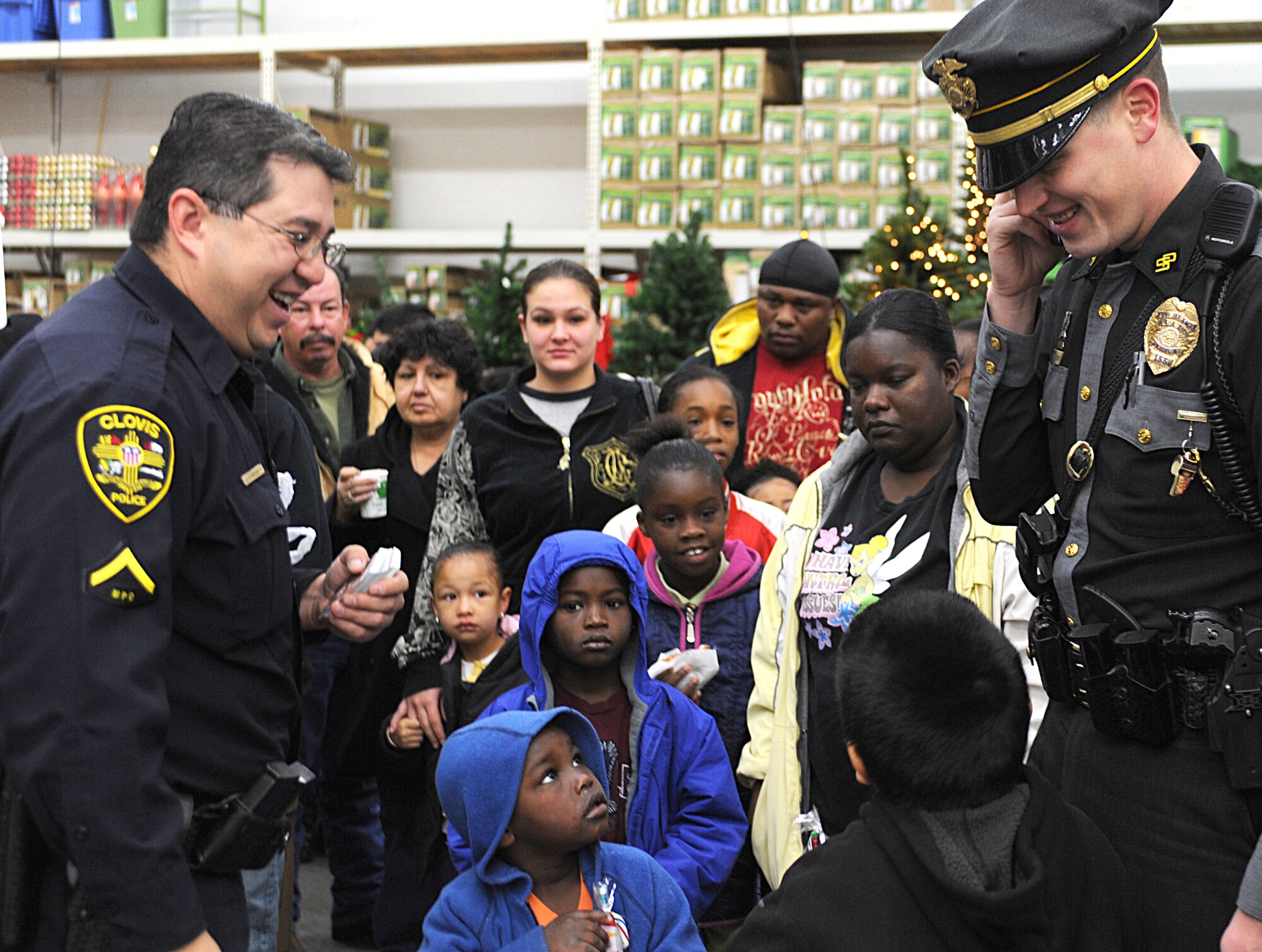 CANNON AIR FORCE BASE, N.M. -- Local Clovis, N.M., police officers hand out gift cards to children during the Shop with a Cop event, Dec. 22. 27th Special Operations Security Forces Airmen joined the volunteer law enforcement effort and shopped with children at a local retailer. (U.S. Air Force photo/Airman 1st Class Evelyn Chavez)  